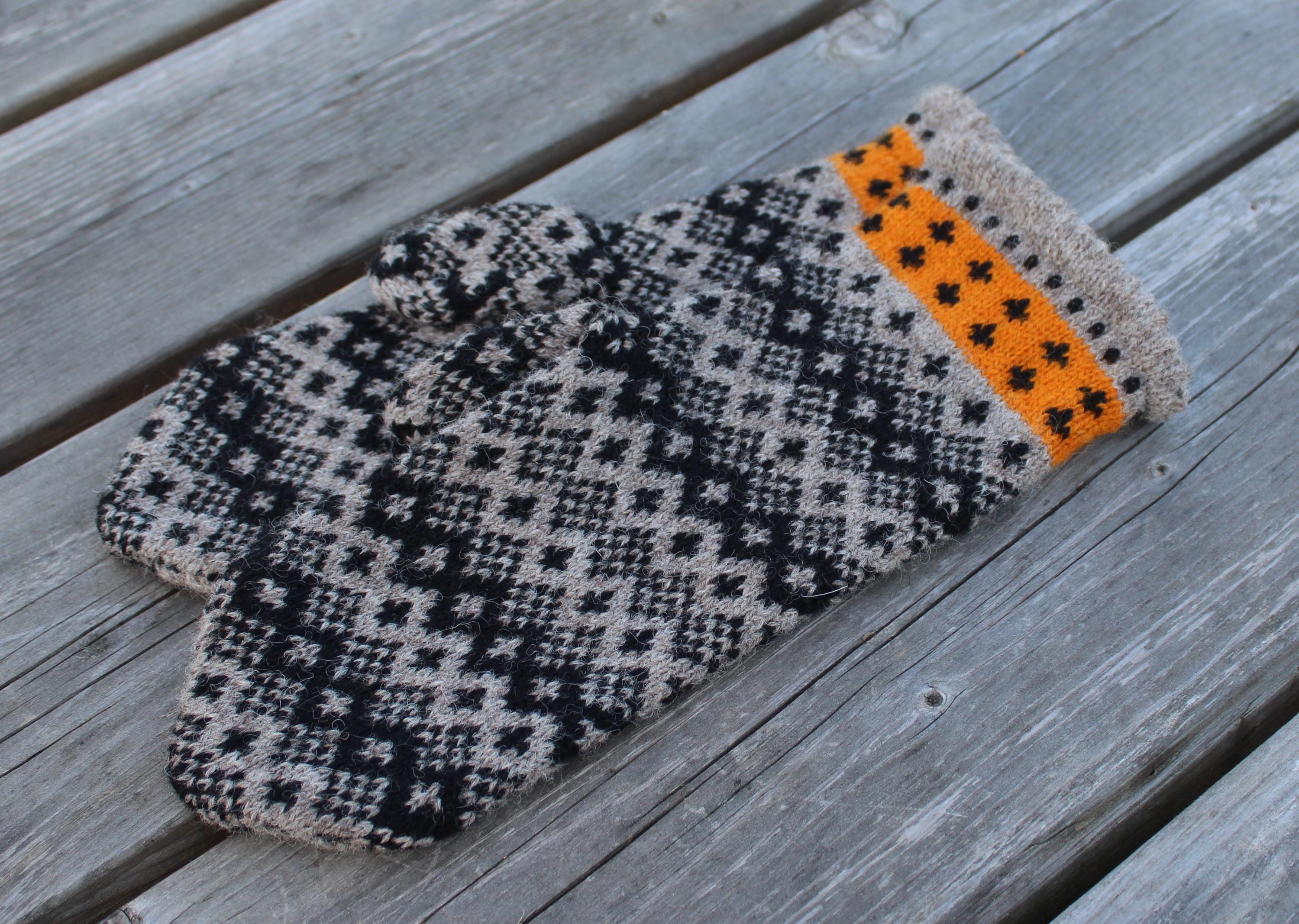 Knitted mittens with a geometric pattern on a wooden surface