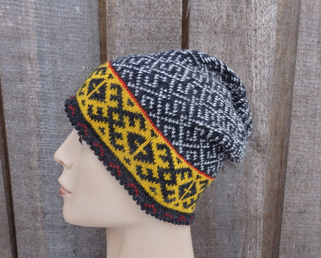 Knitted hat with geometric pattern on a mannequin head against a wooden background