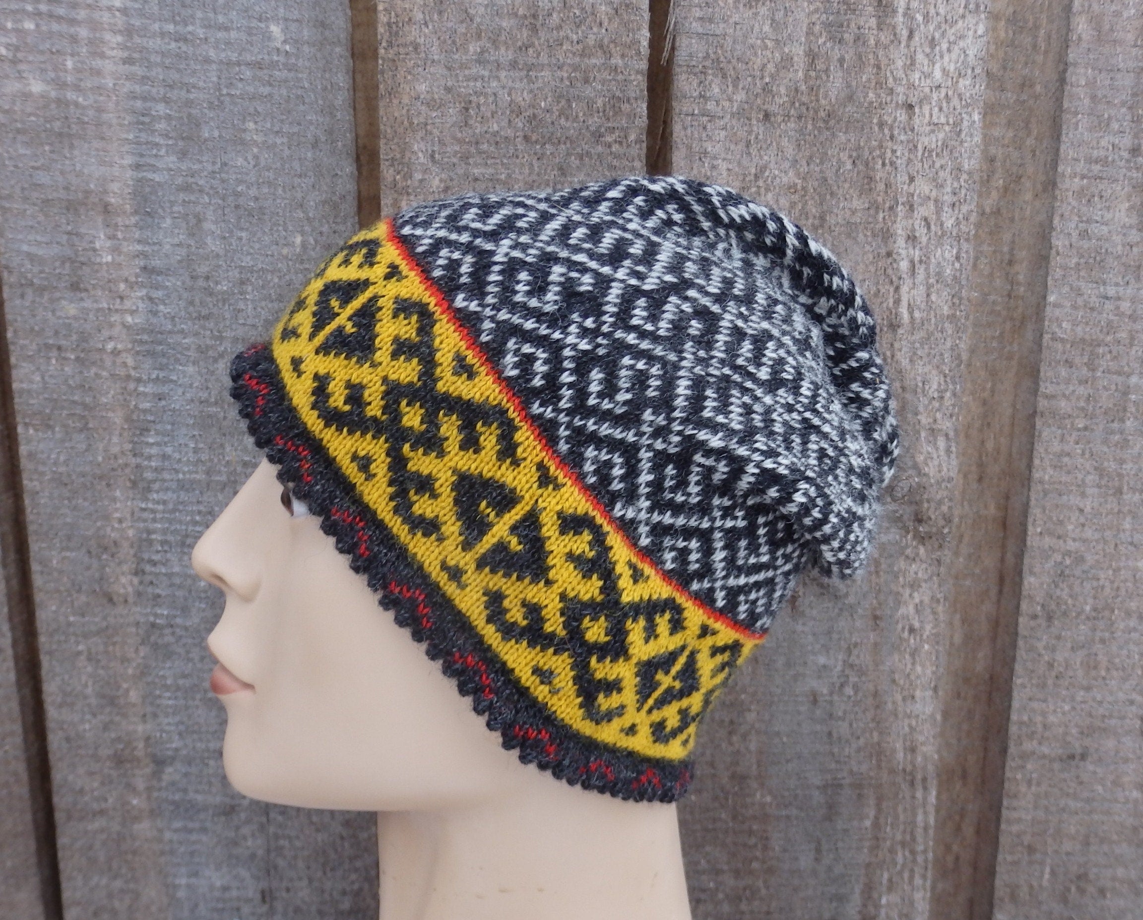 Knitted hat with geometric pattern on a mannequin head against a wooden background