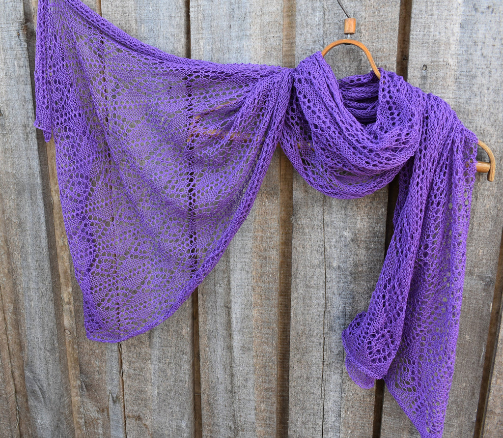 Purple knitted shawl draped over a wooden surface