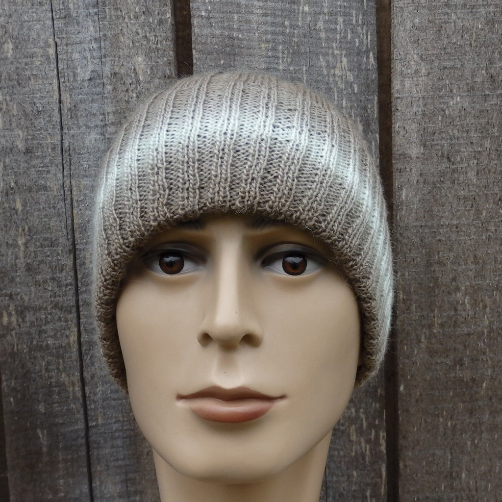 Mannequin head wearing a knitted beanie against a wooden background