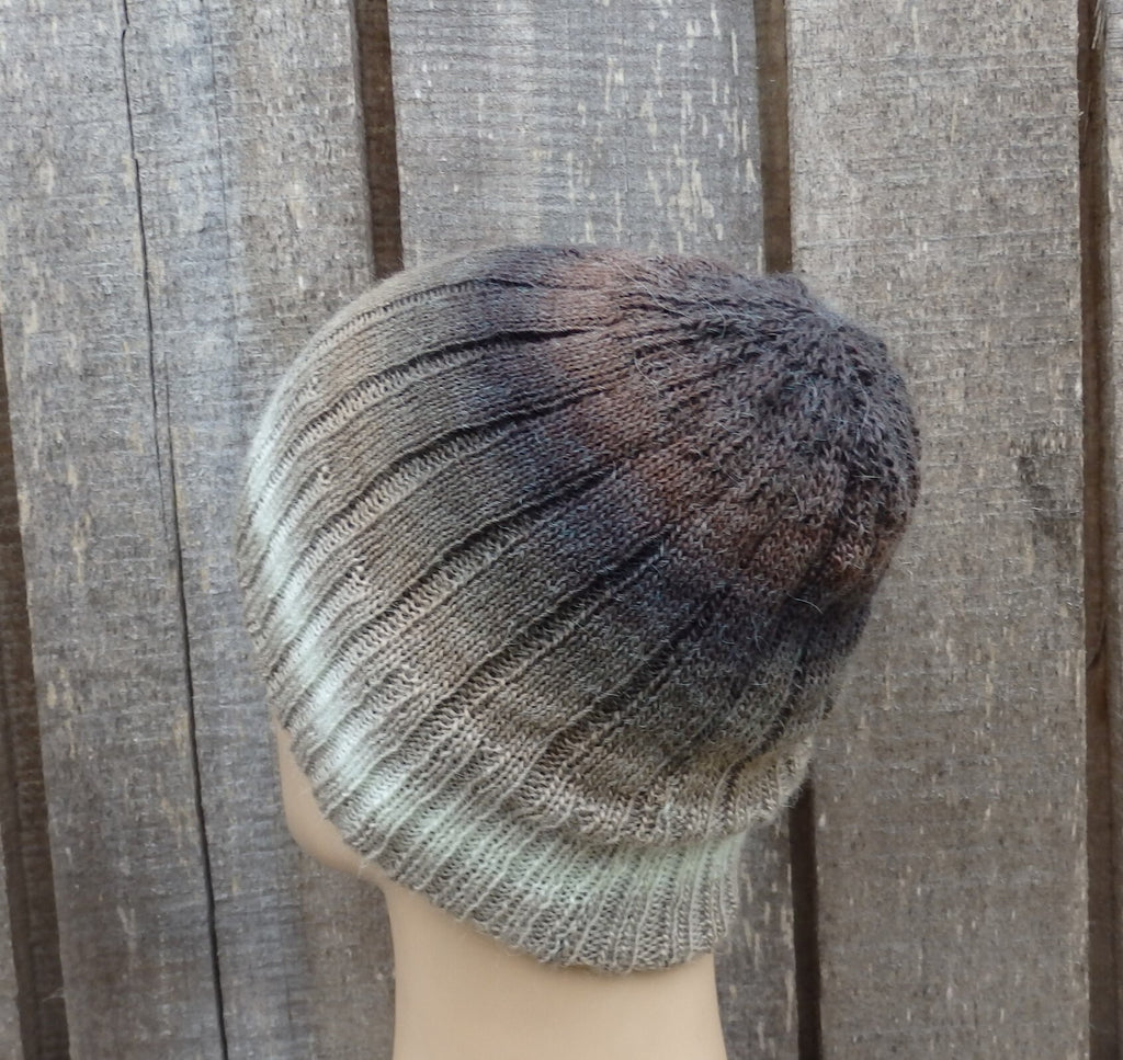 Knitted beanie on a mannequin head against a wooden background