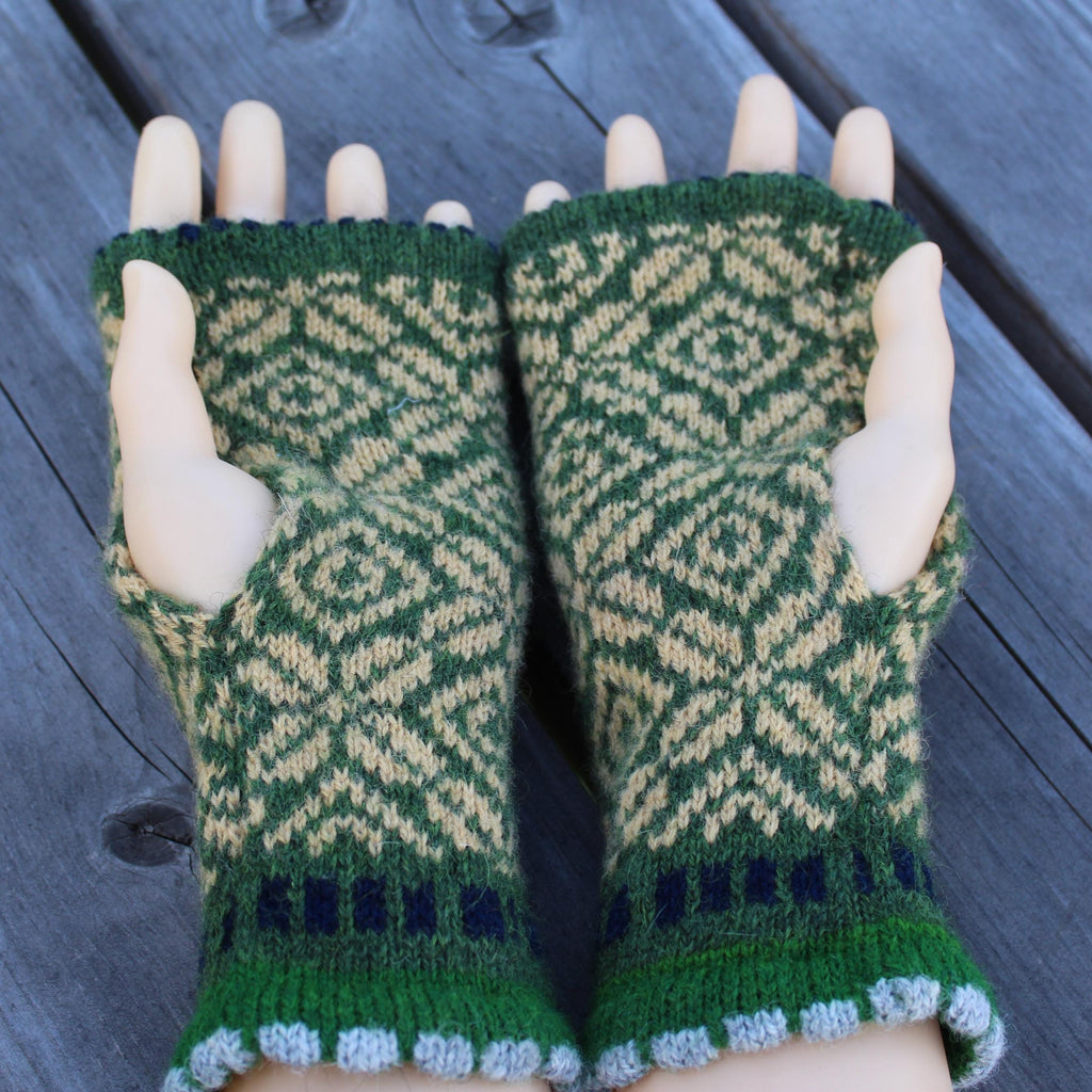 Green and yellow wool arm warmers held on a wooden surface