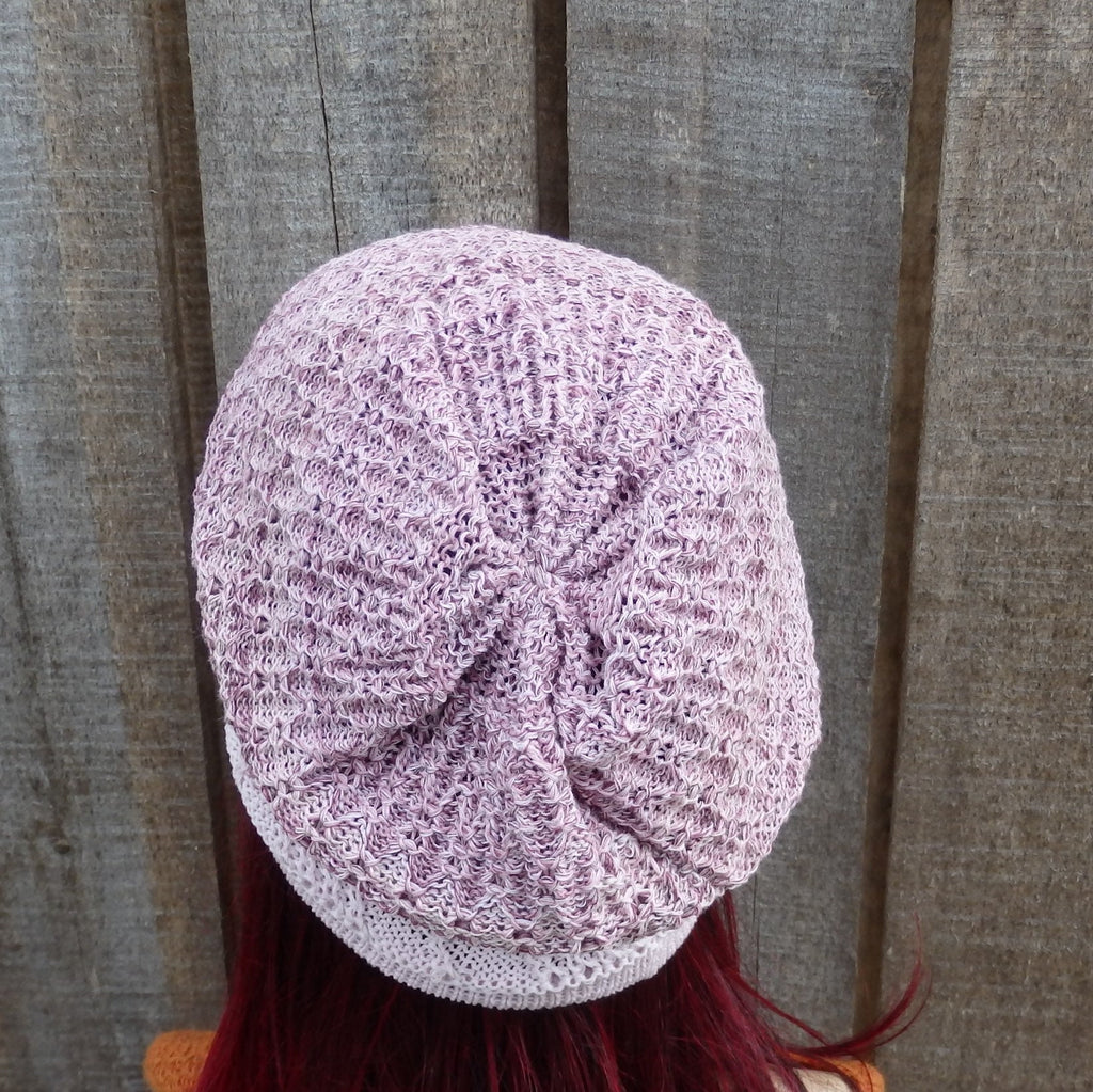 Purple textured beanie on a person with red hair against a wooden background