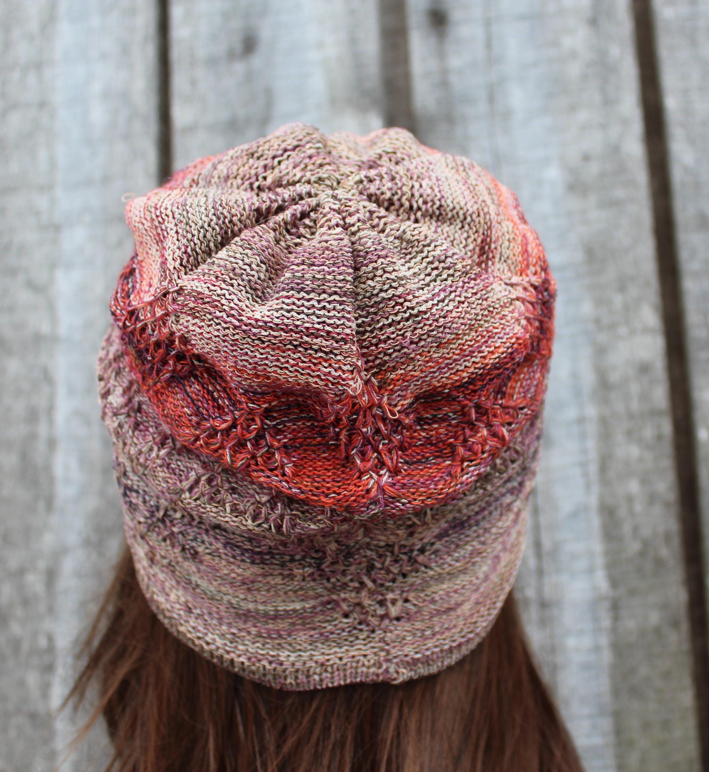 Knitted hat with a textured pattern worn by a person against a neutral background
