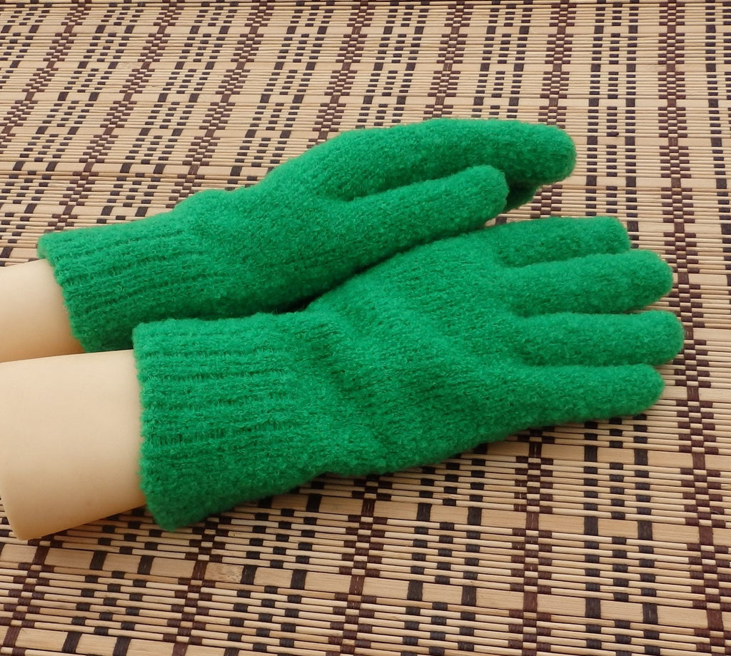 Green gloves on a person's hands on a woven mat background