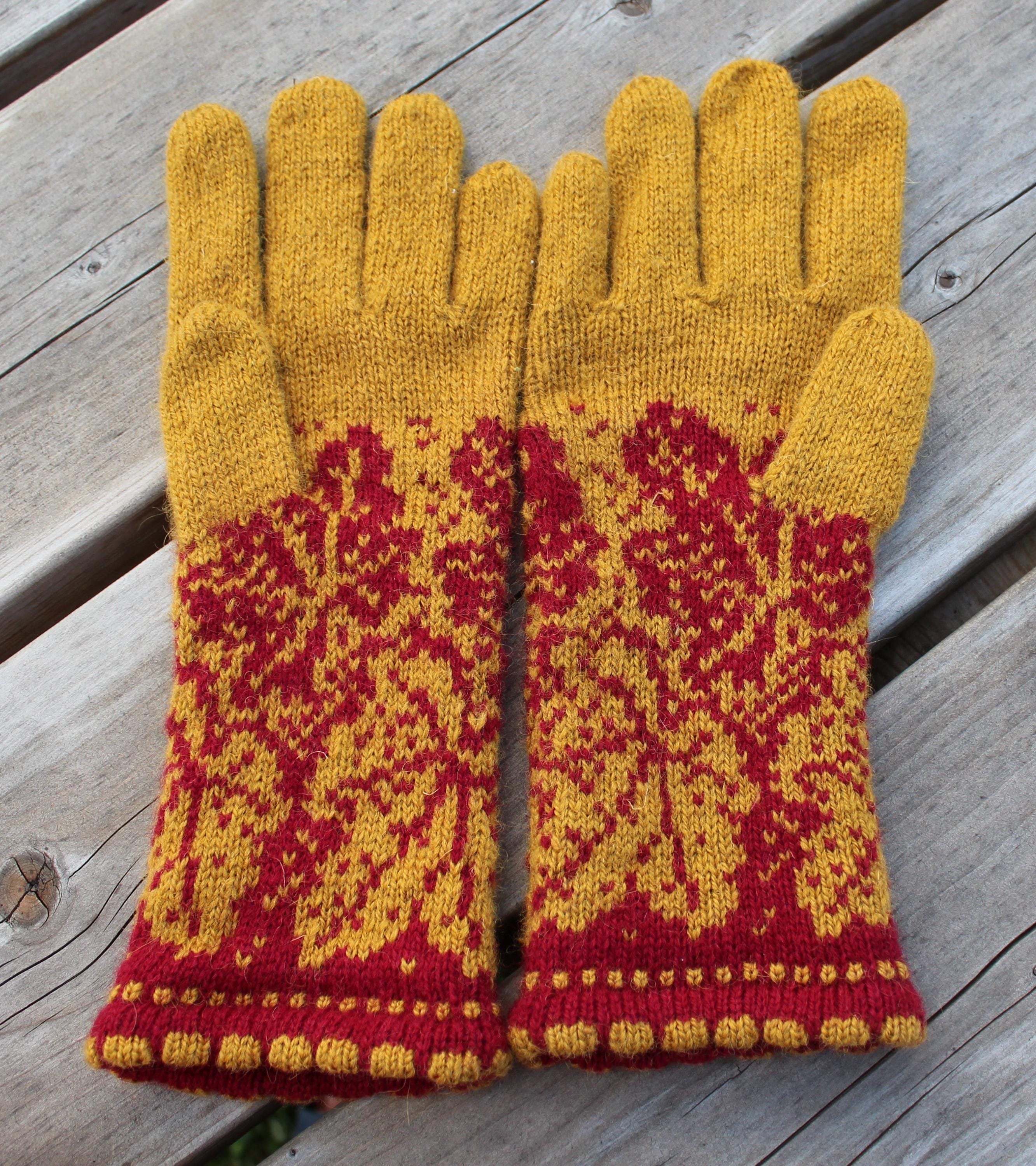 Pair of yellow and red patterned gloves on a wooden surface