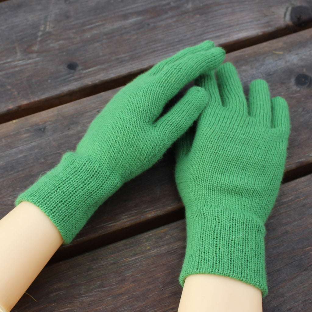 Green gloves on a wooden surface