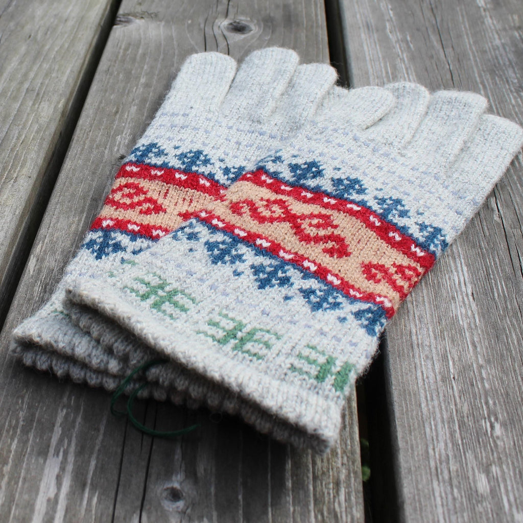 Pair of gray gloves with a colorful pattern on a wooden surface