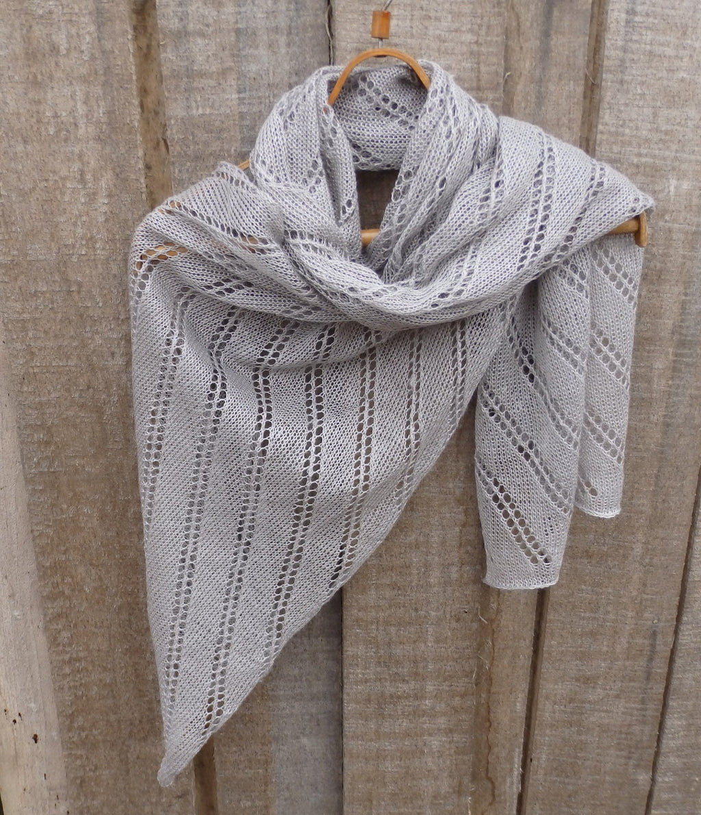 Knitted shawl draped over a wooden surface