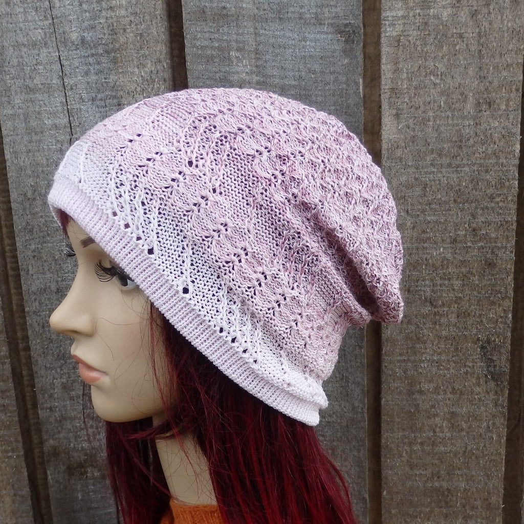 Pink knitted hat on a mannequin head against a wooden background