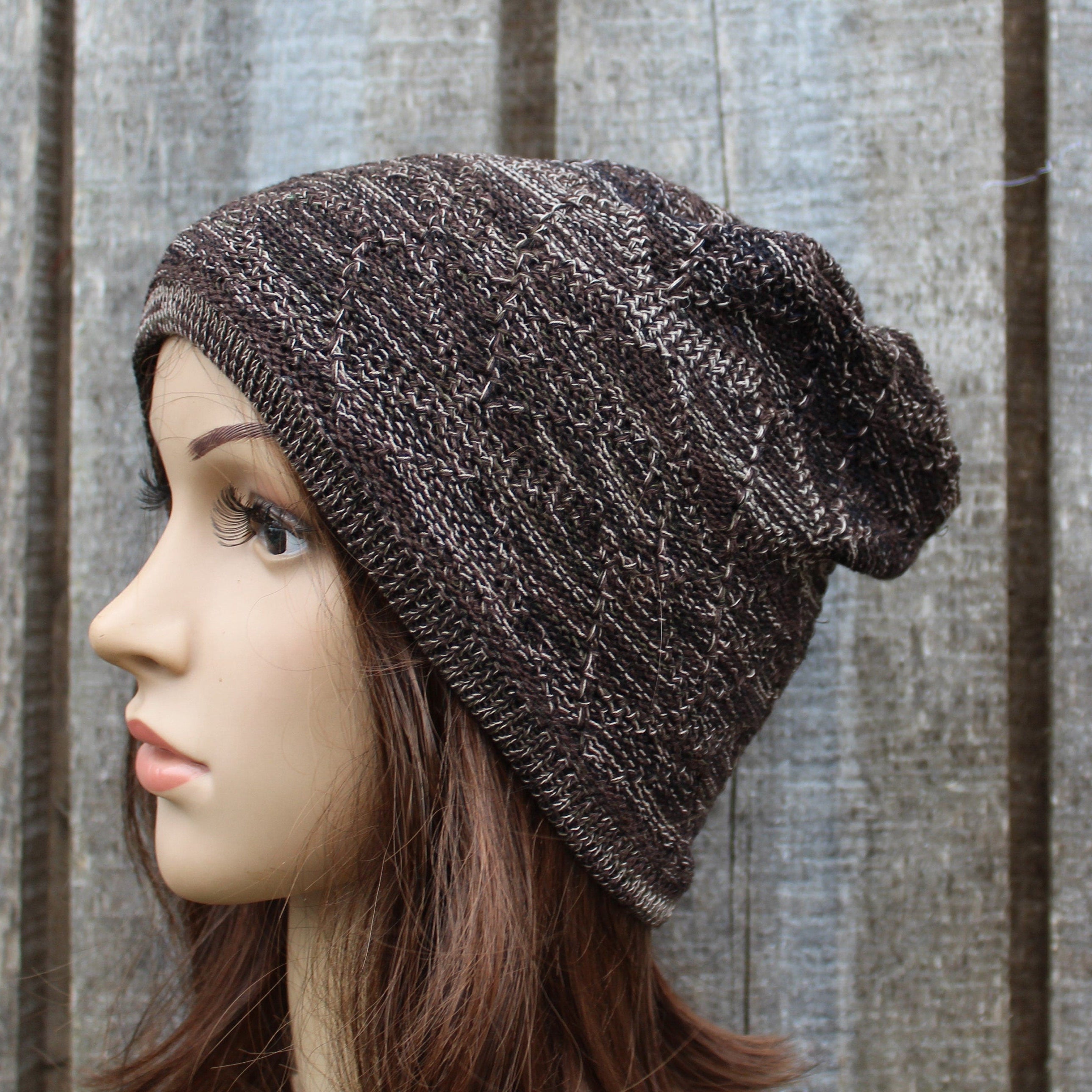 Brown knit beanie worn by a mannequin against a wooden background