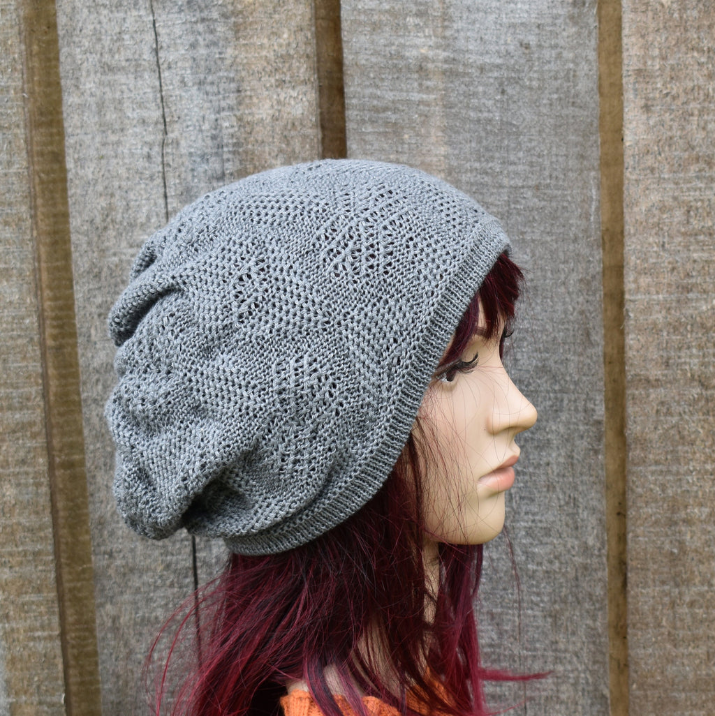 Person wearing a gray knit beanie against a wooden background
