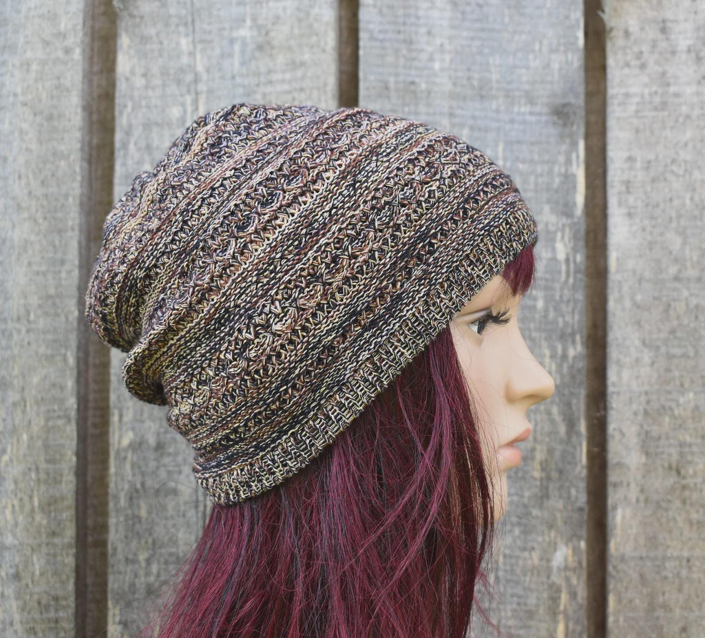 Person wearing a patterned knit beanie against a wooden fence background