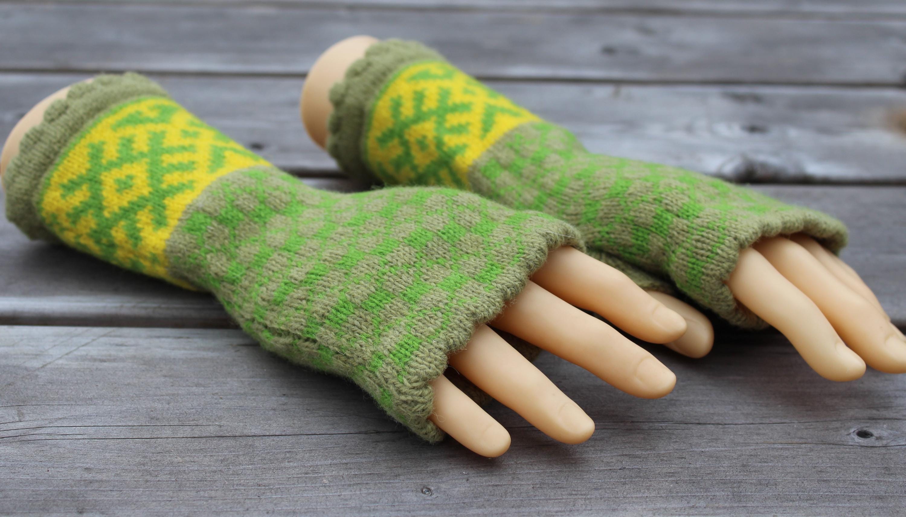 Green and yellow patterned fingerless gloves on a wooden surface