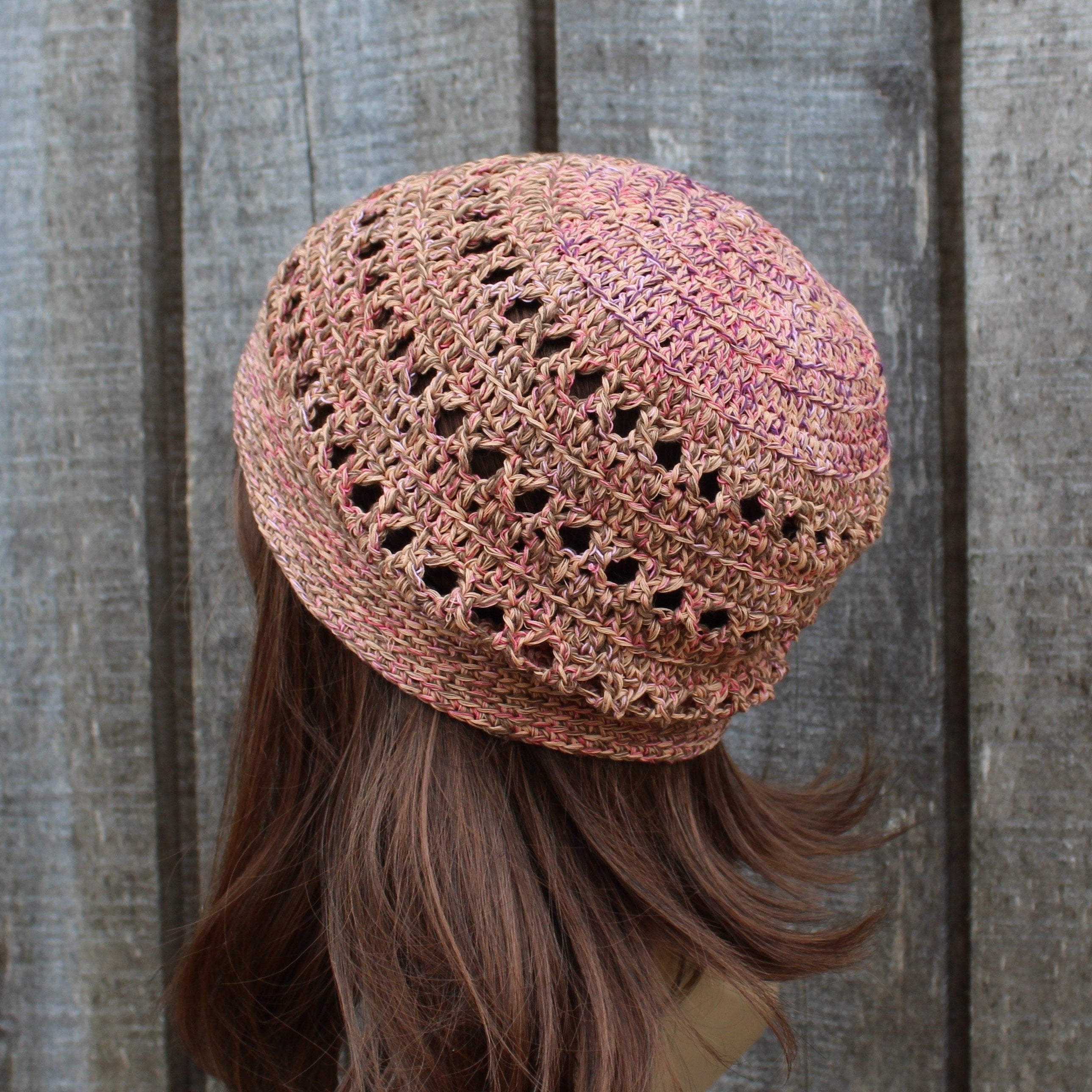 Crocheted summer hat on a person with long hair against a wooden background