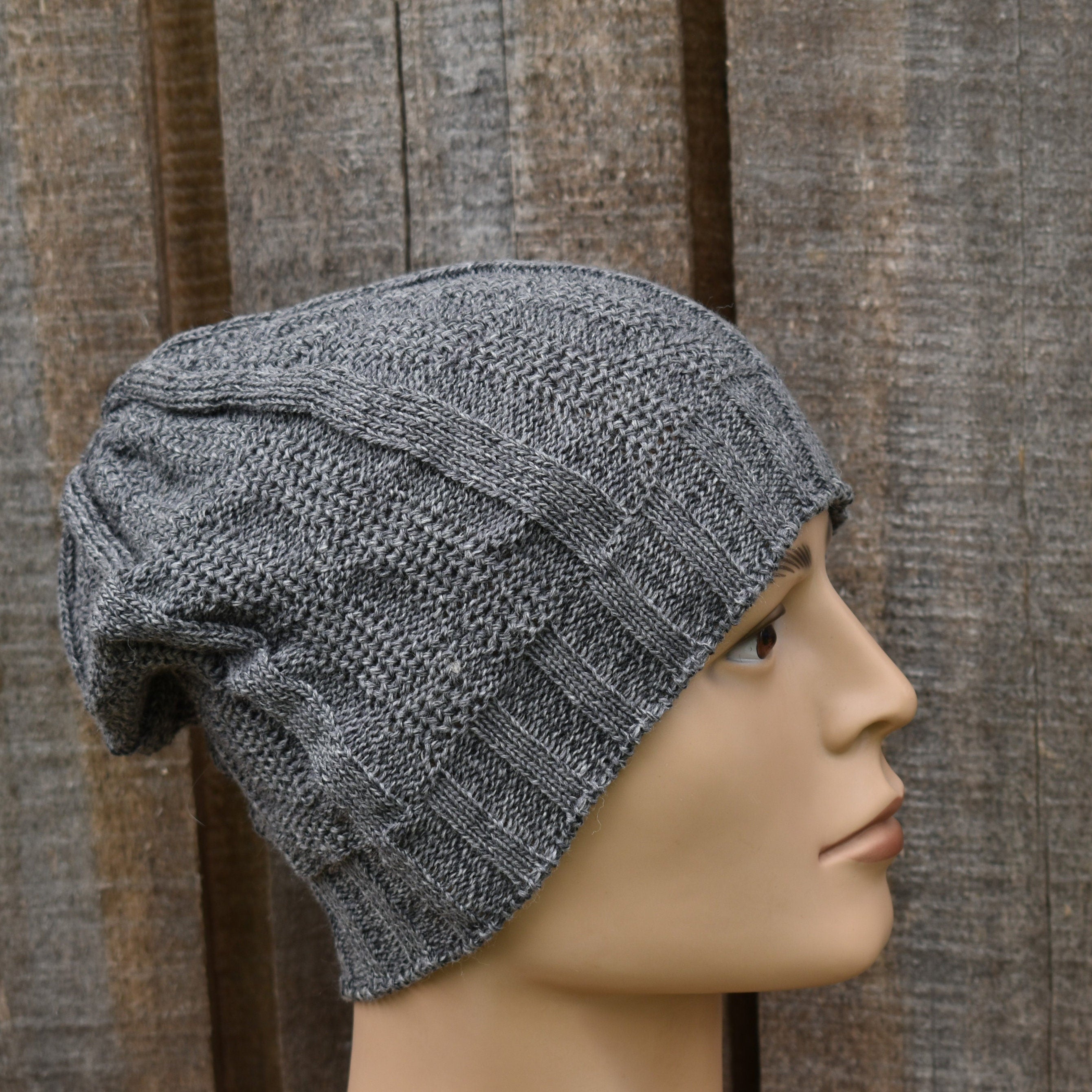 Gray knit beanie on a mannequin head against a wooden background