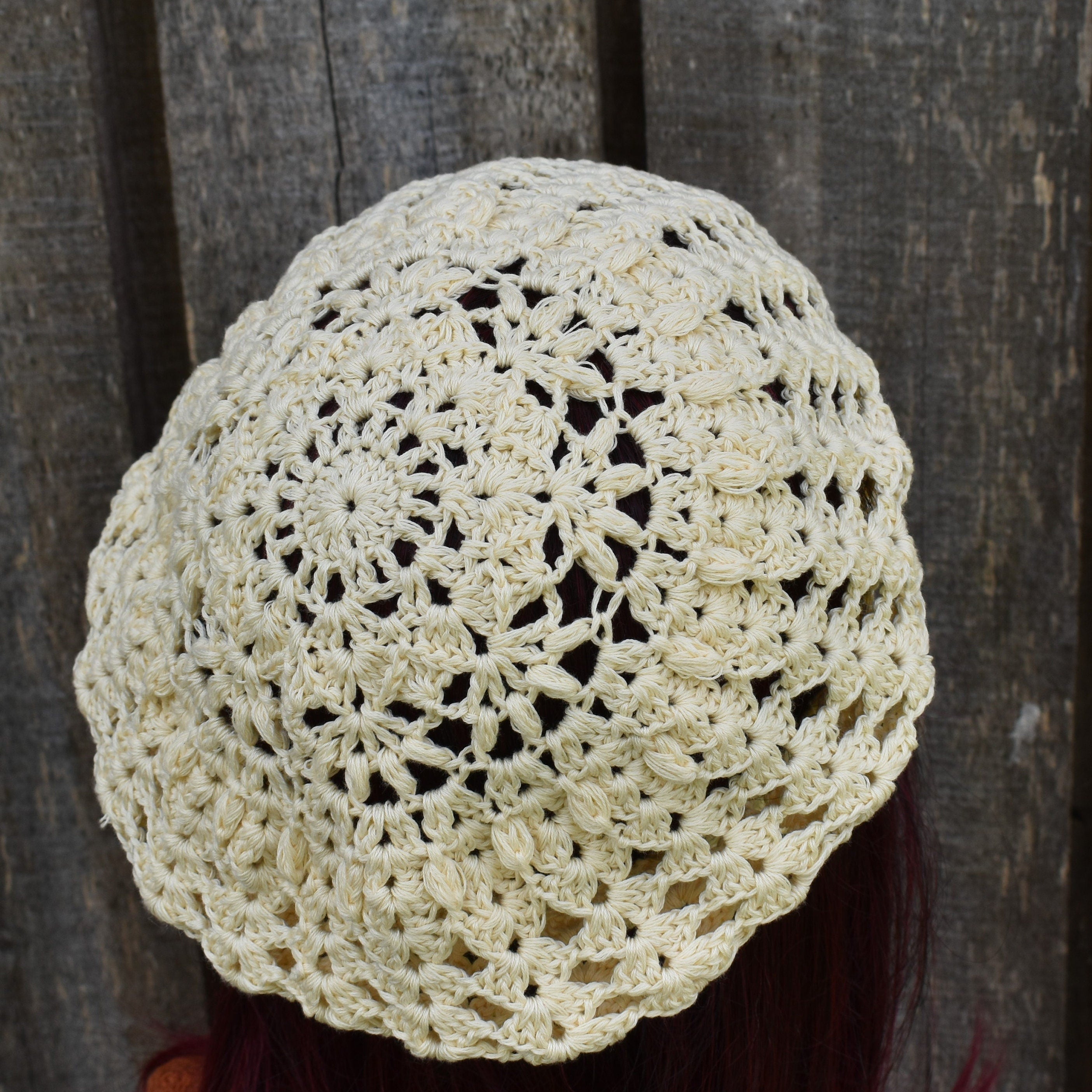 Beige crochet hat on a wooden background