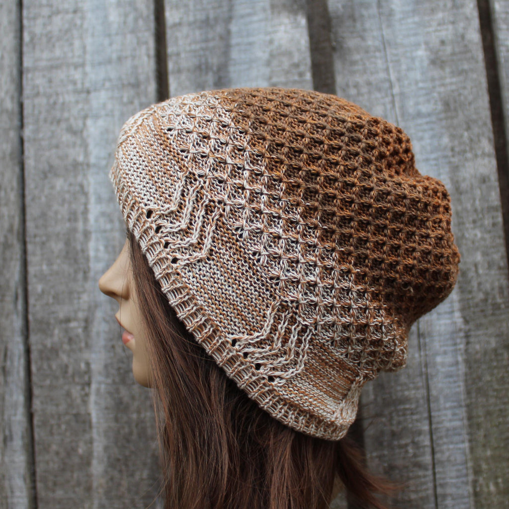 Knitted brown beanie on a mannequin head against a wooden background