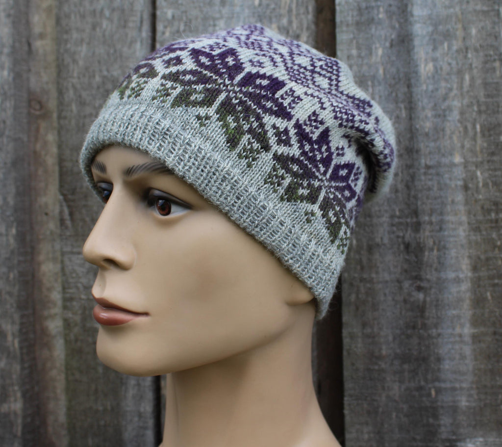 Knitted hat with a pattern worn by a mannequin against a wooden background