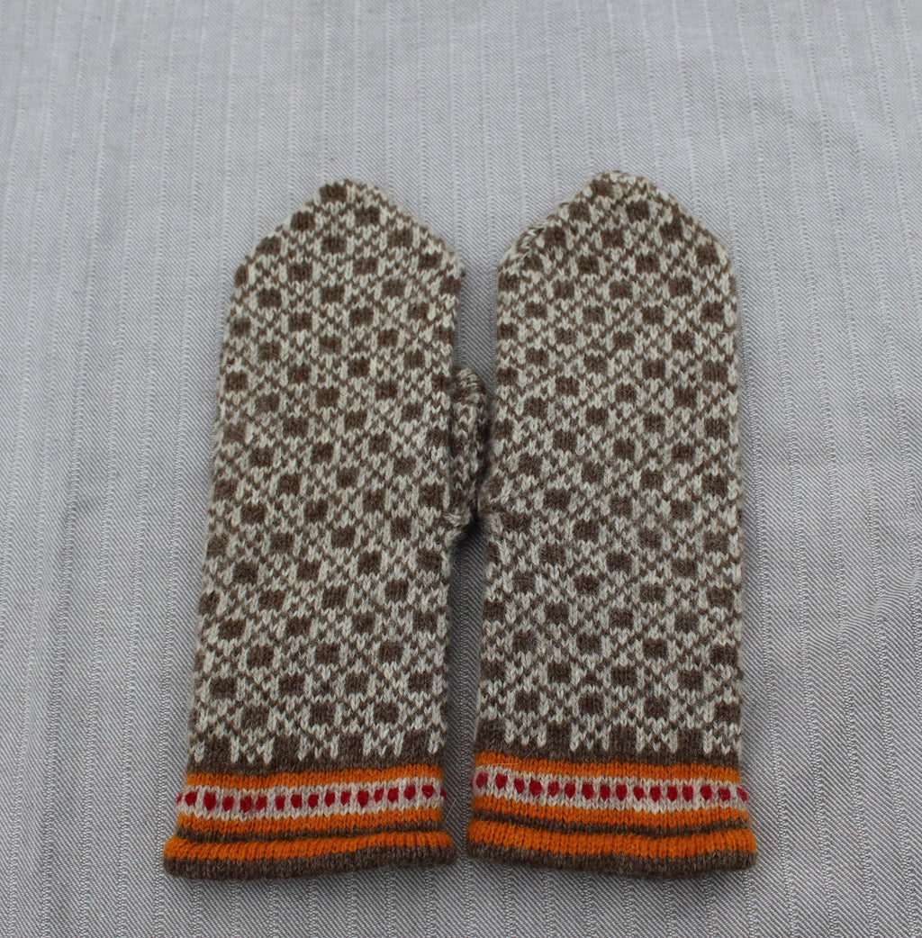 Pair of patterned mittens on a textured fabric background