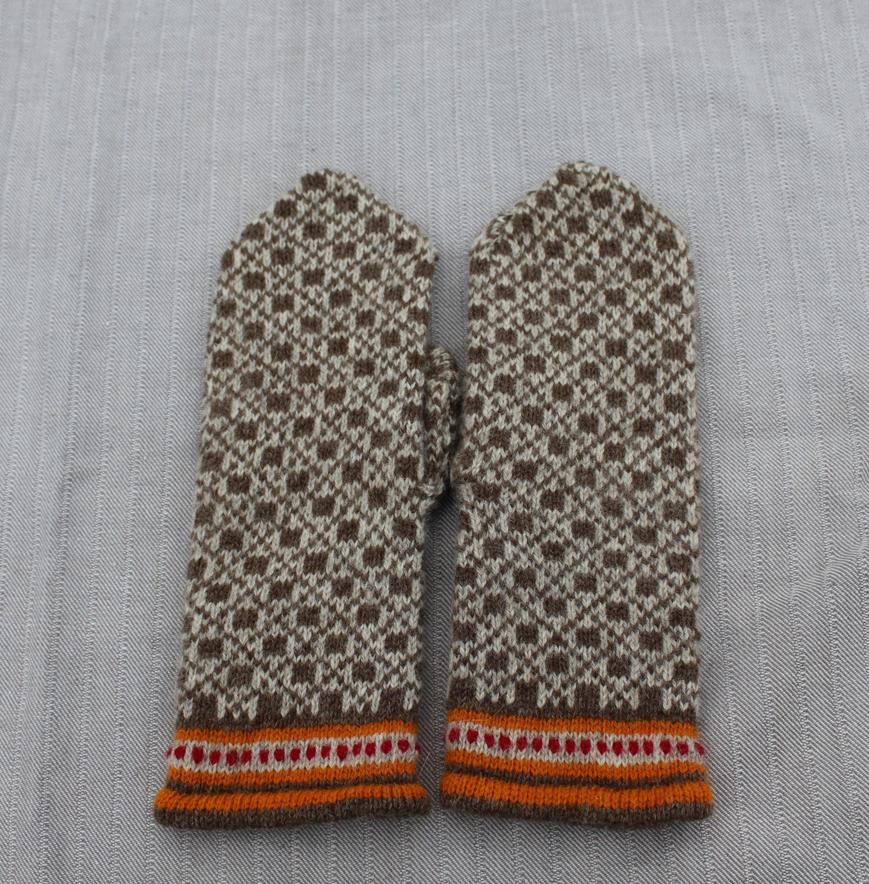 Pair of patterned mittens on a textured fabric background