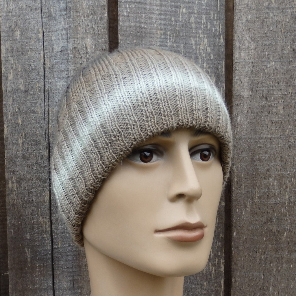 Mannequin head wearing a knitted beanie against a wooden background