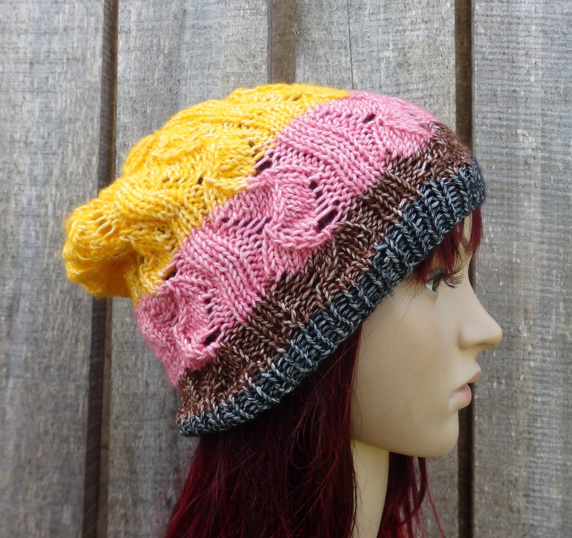 Colorful knitted beanie on a mannequin head against a wooden background