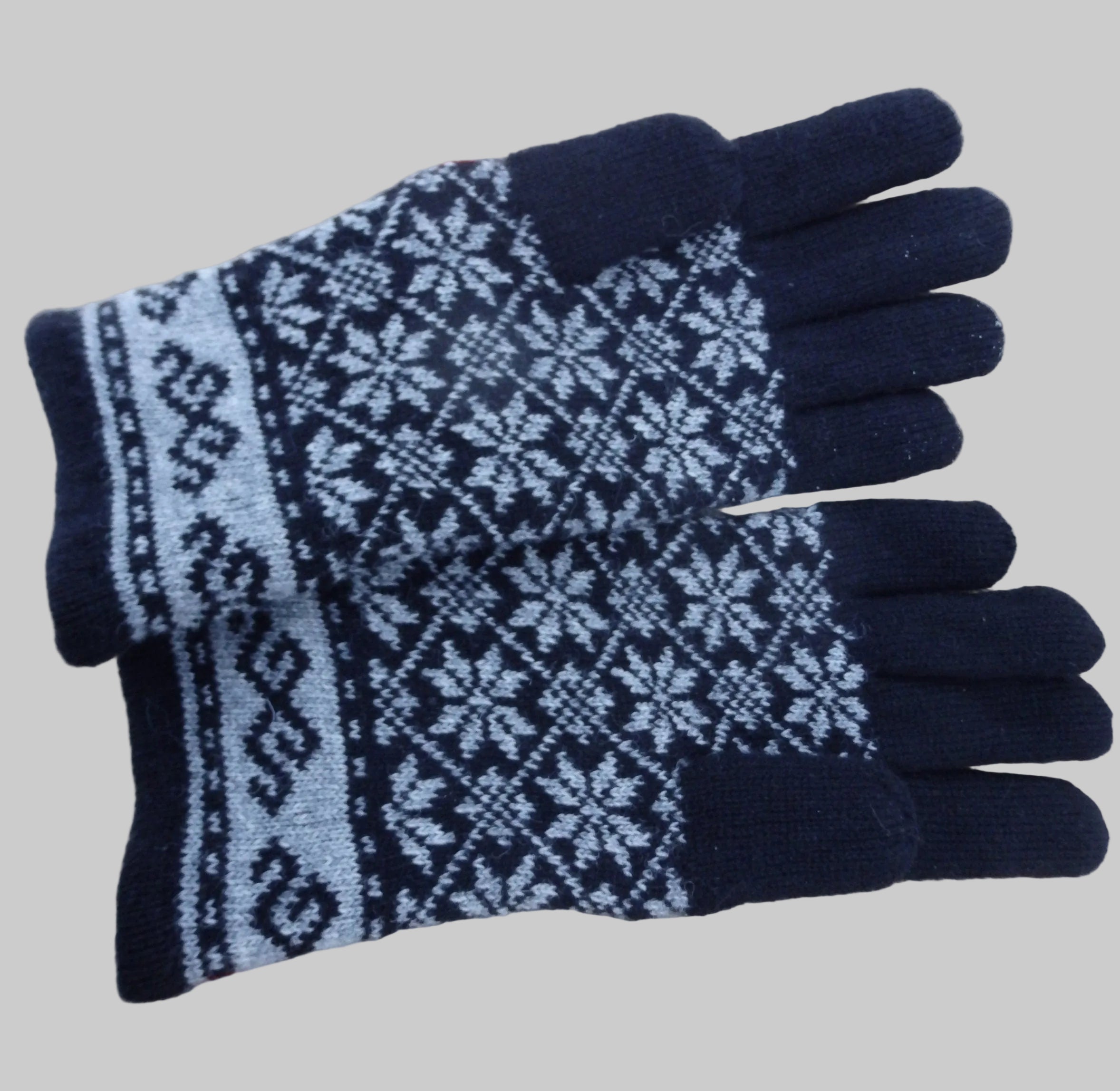 Pair of black and gray patterned gloves on a wooden surface