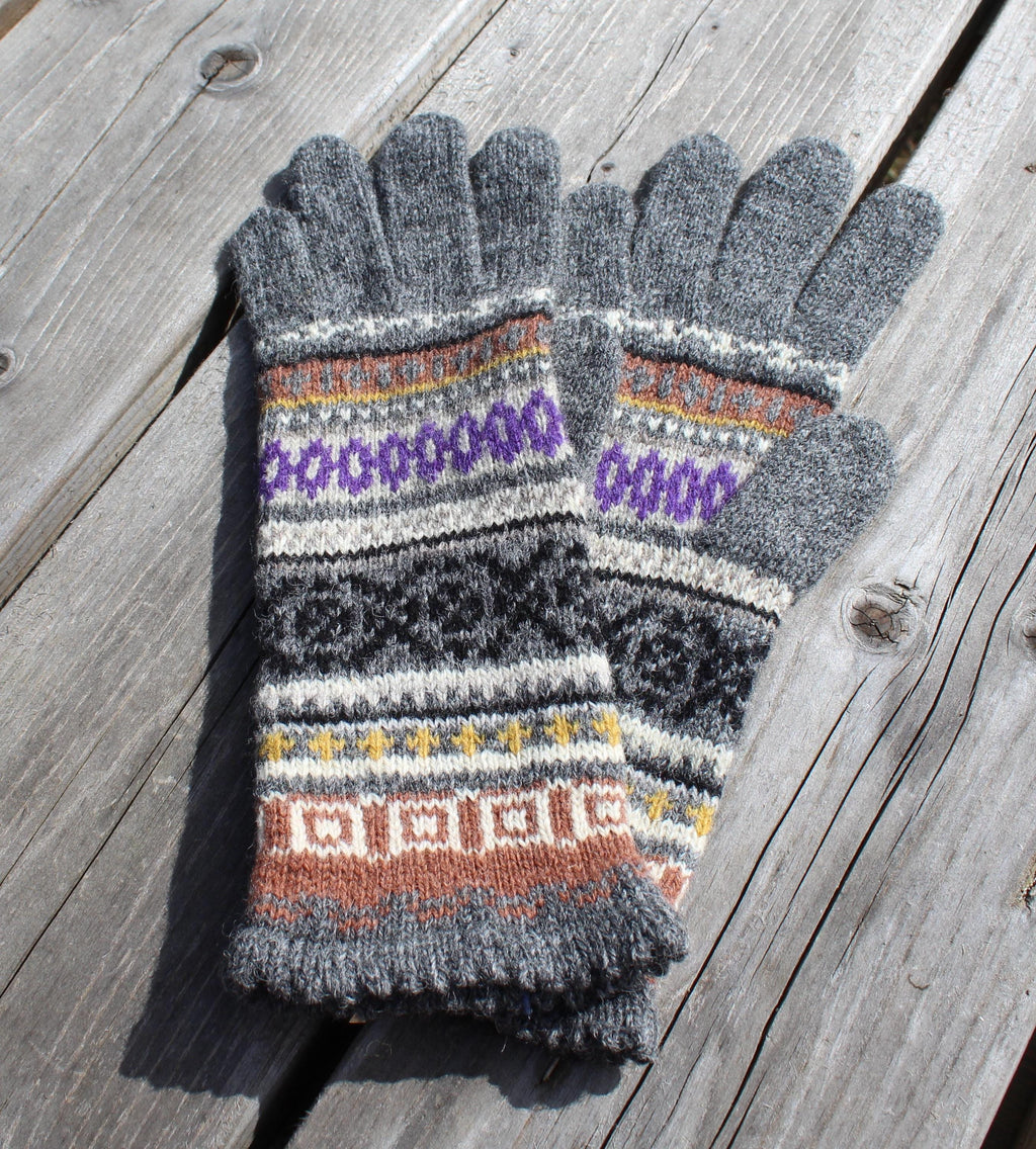 Pair of gray gloves with colorful pattern on a wooden surface