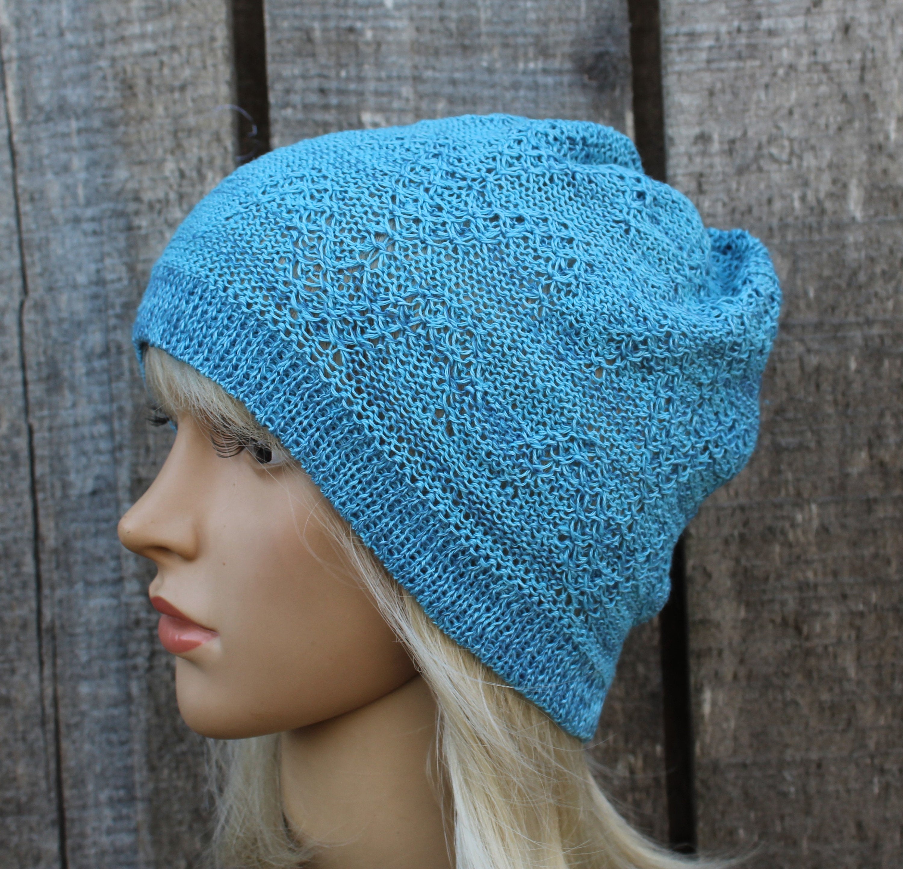 Blue knitted beanie on a mannequin head against a wooden background