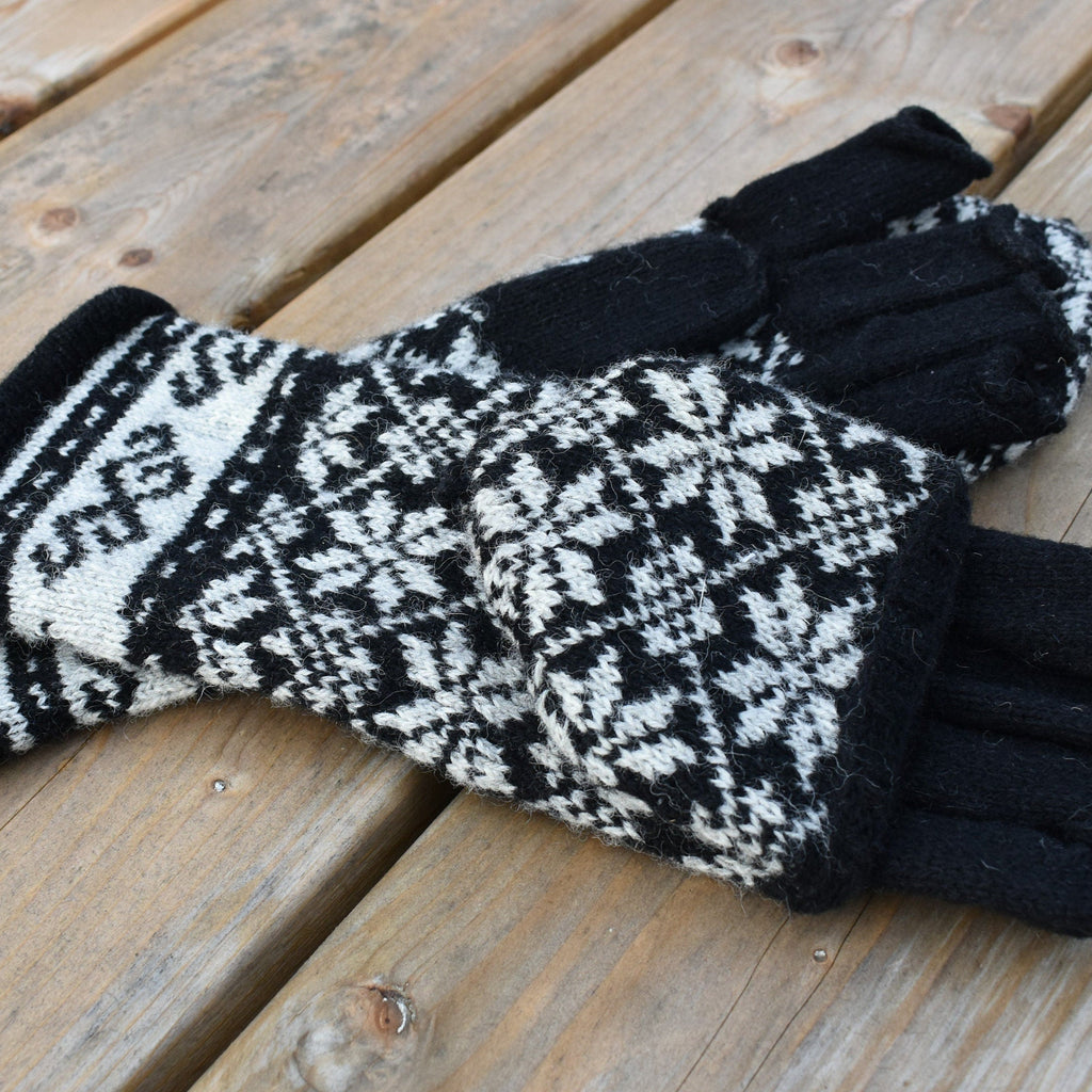 Pair of black and white patterned gloves on a wooden surface