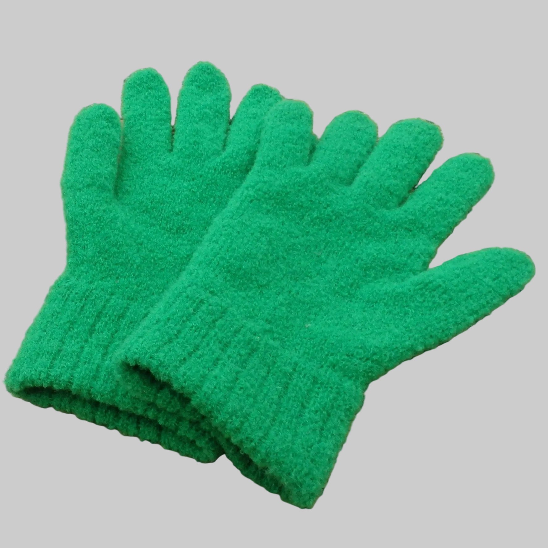 Pair of green gloves on a woven mat