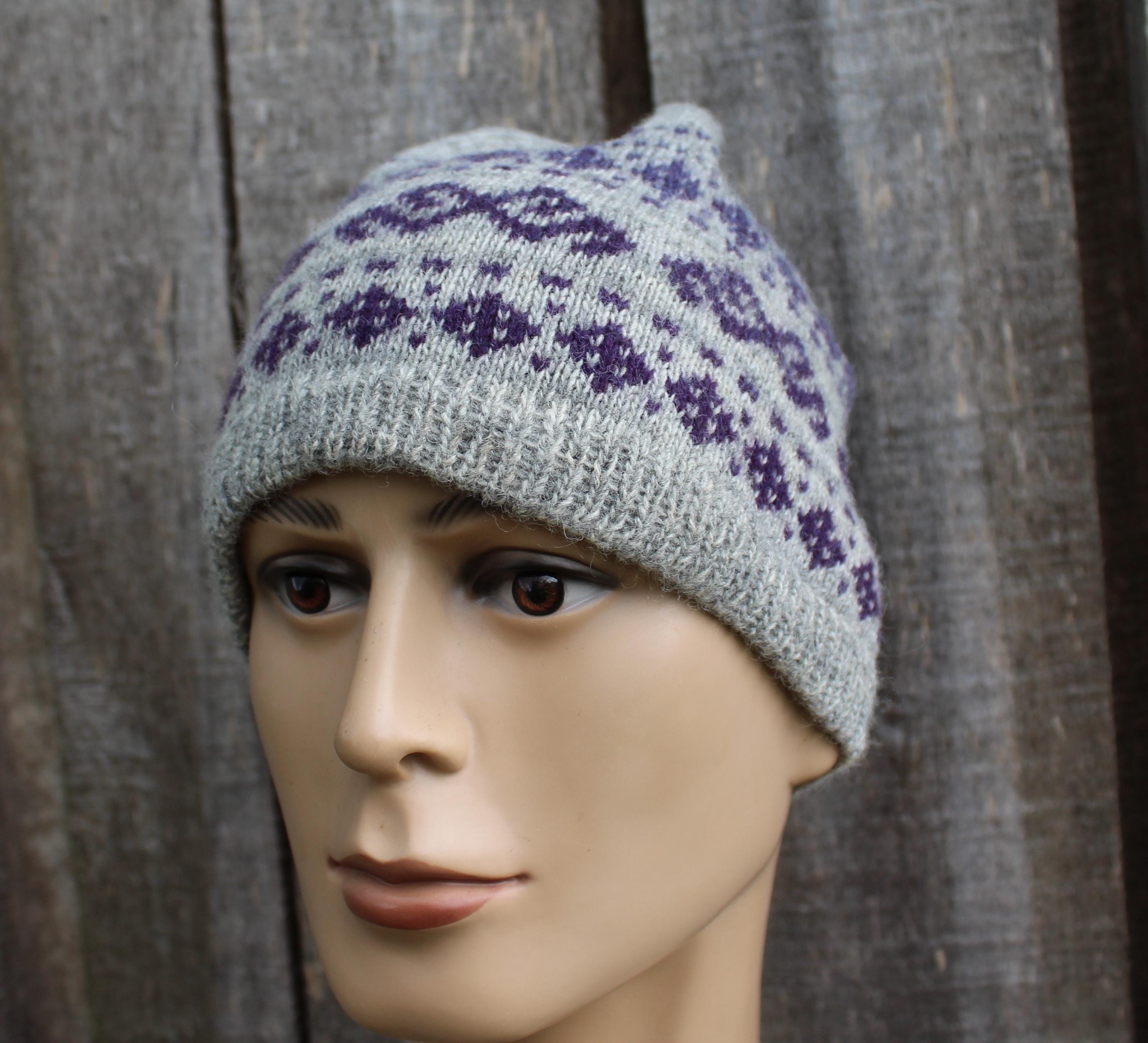 Gray knit hat with purple patterns on a mannequin head against a wooden background