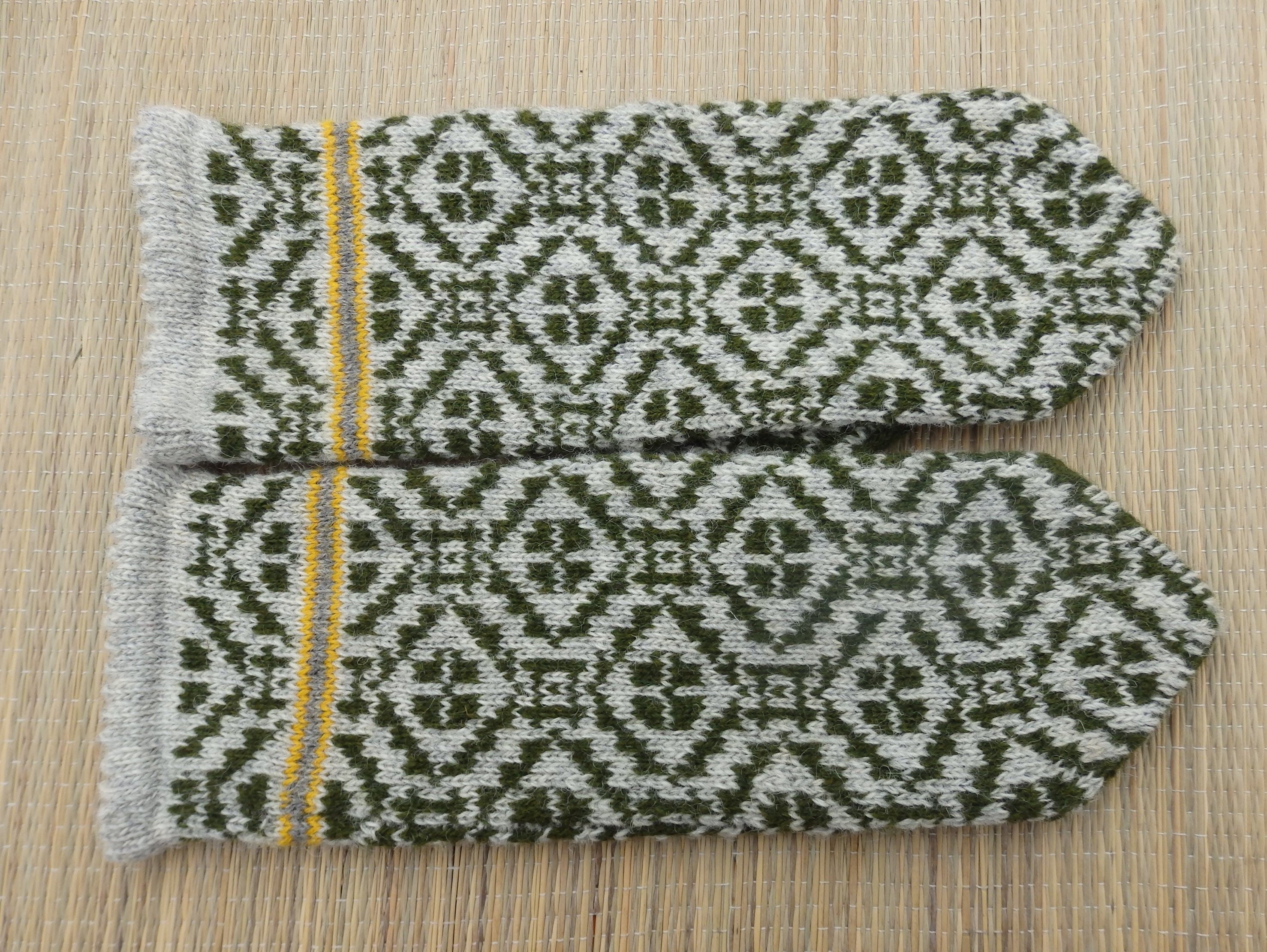 Pair of patterned mittens on a wooden surface