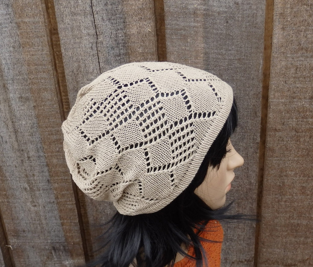 Beige knitted hat worn by a person with black hair against a wooden panel background
