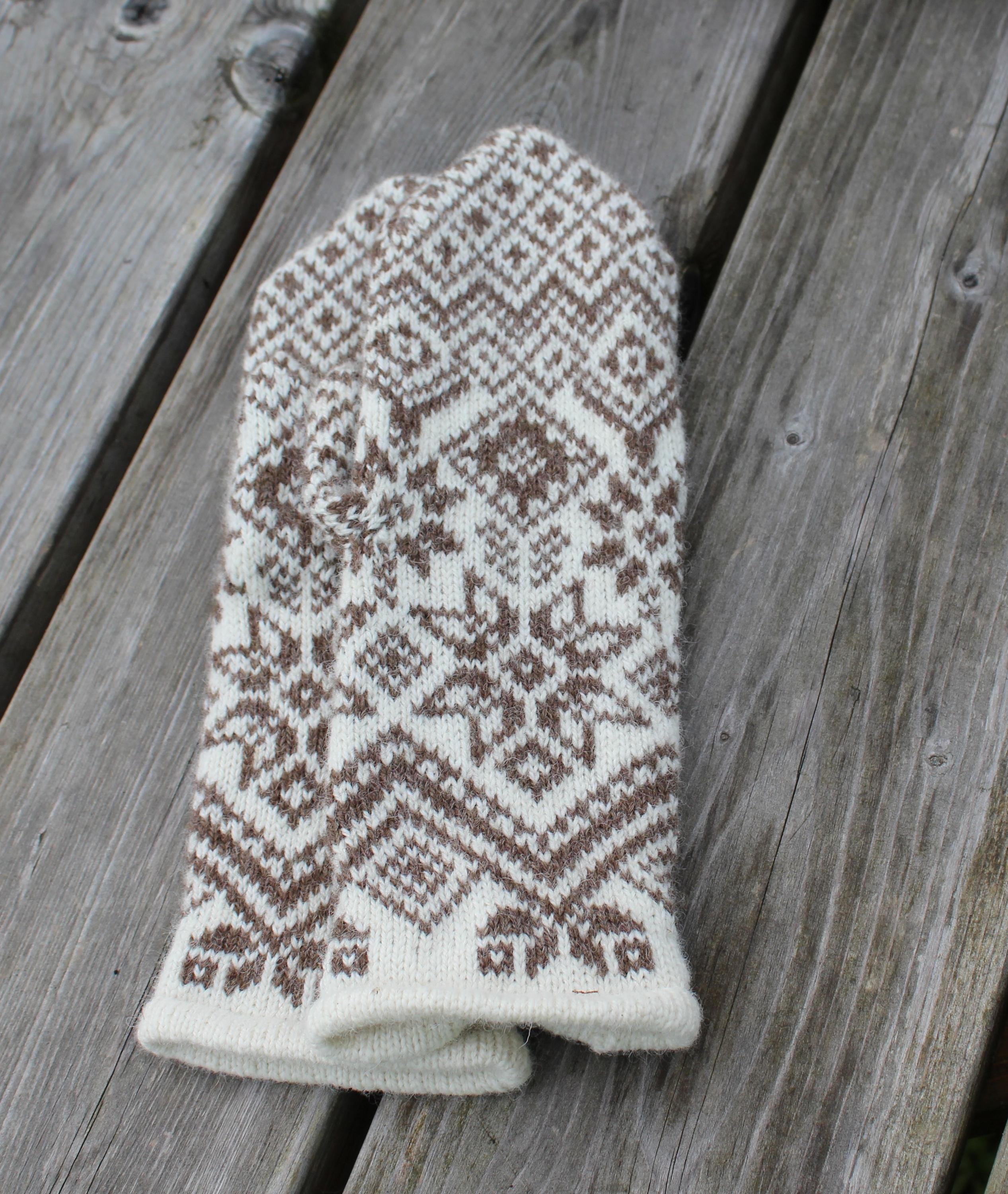 Knitted mitten with a pattern on a wooden surface