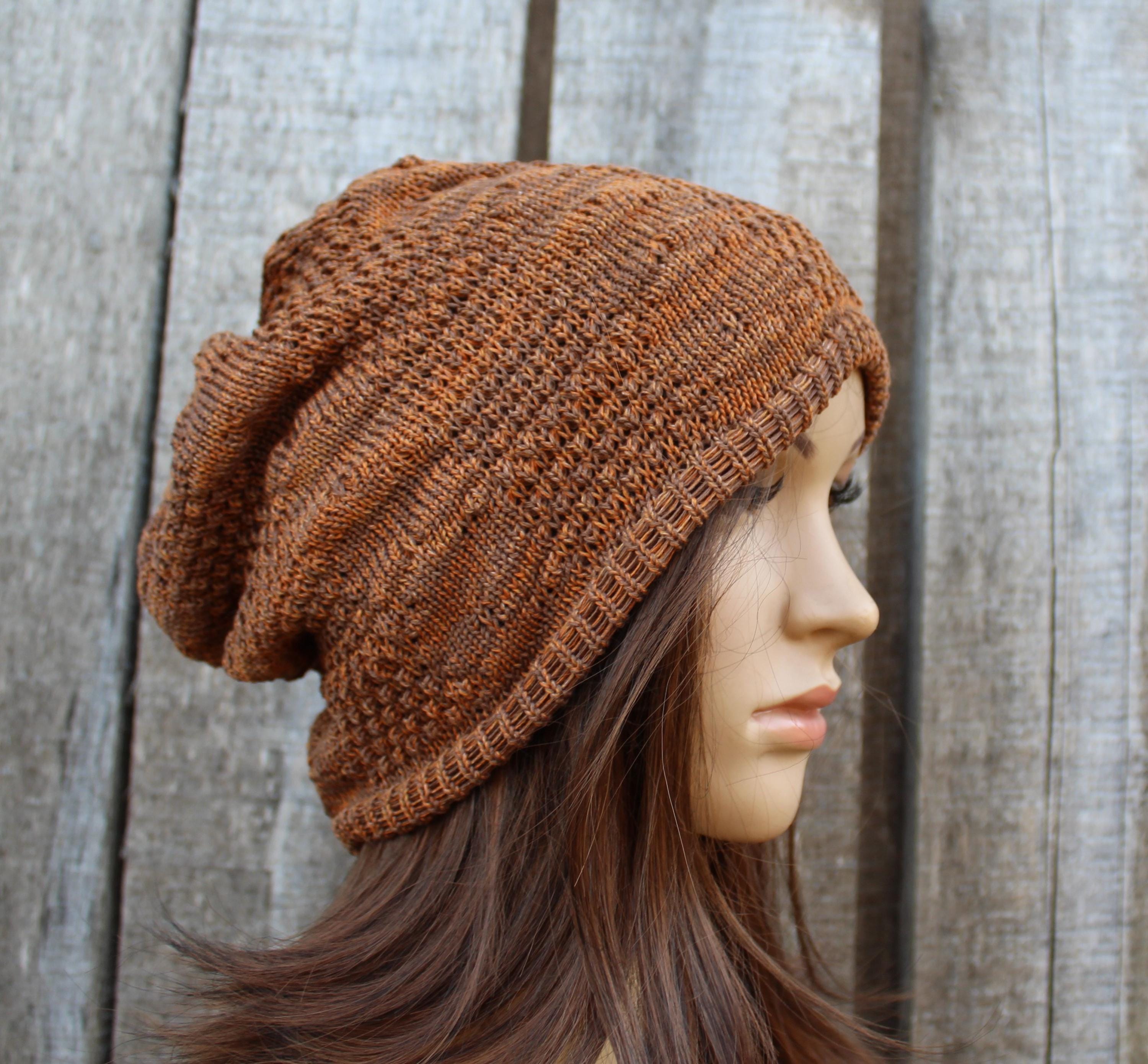 Brown knitted beanie worn by a mannequin against a wooden background