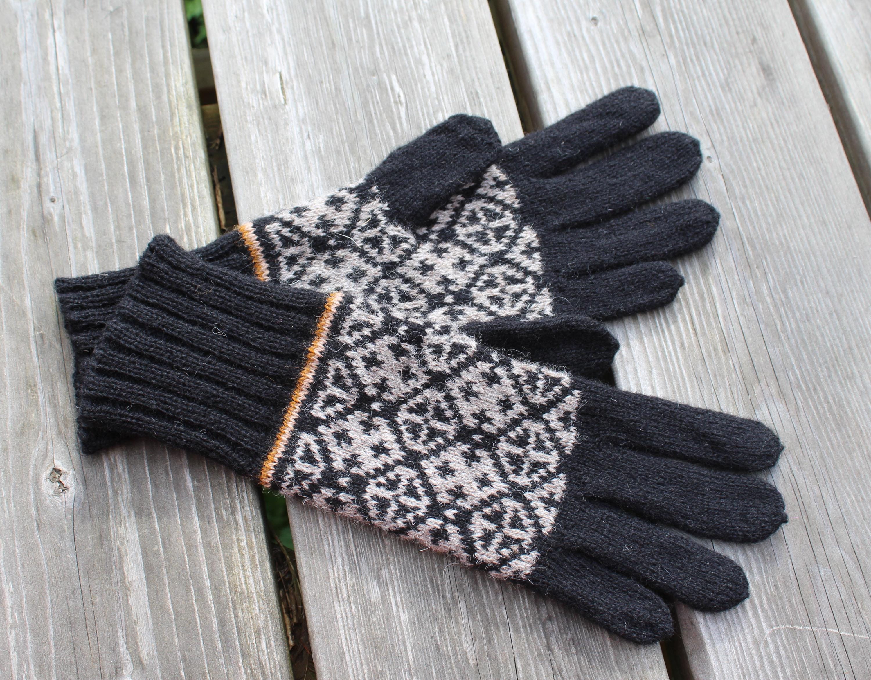 Pair of gloves with a patterned palm on a wooden surface