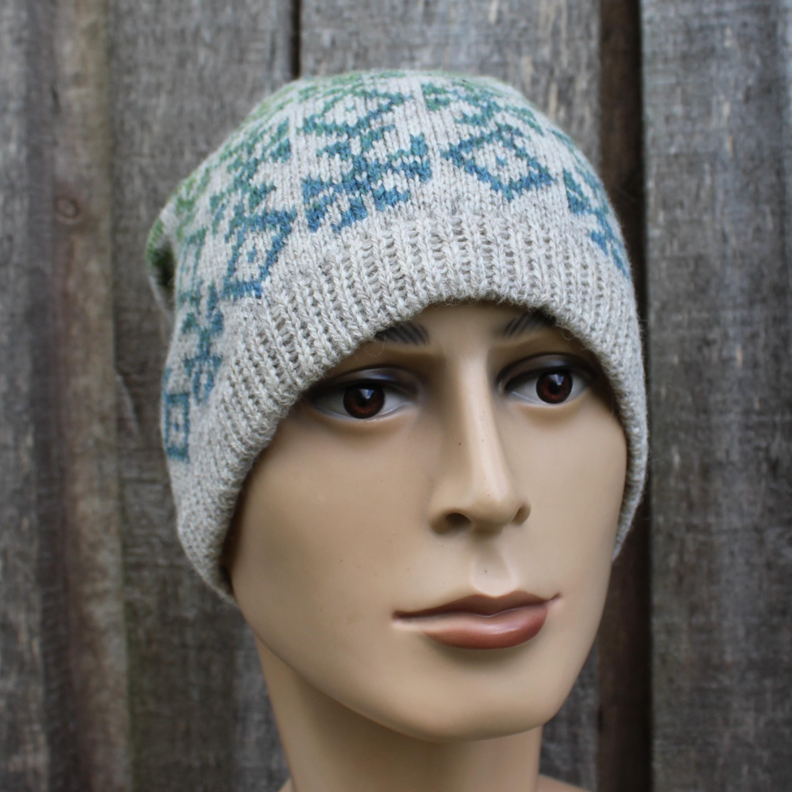 Knitted hat with a pattern worn by a mannequin against a wooden background