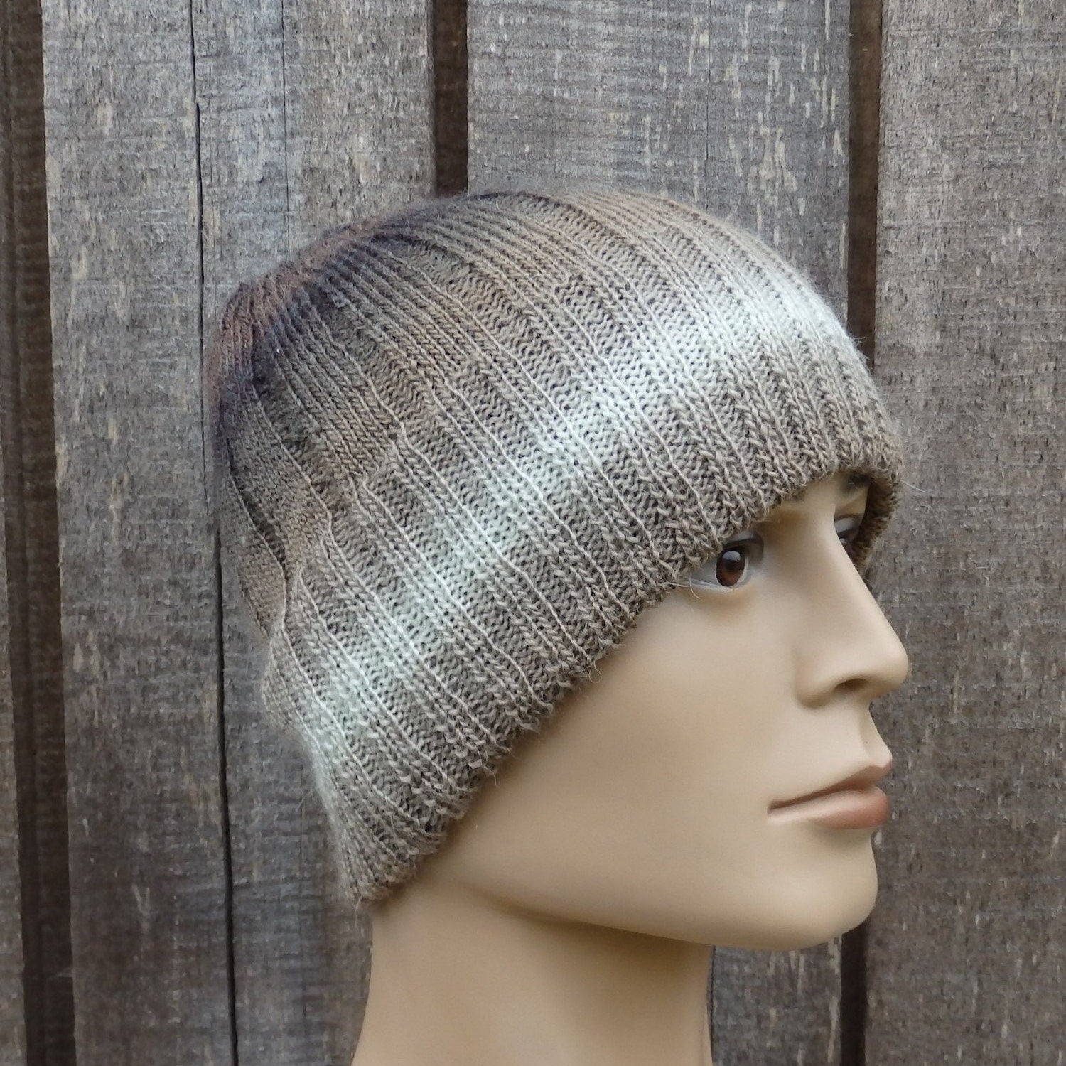 Knitted beanie on a mannequin head against a wooden background