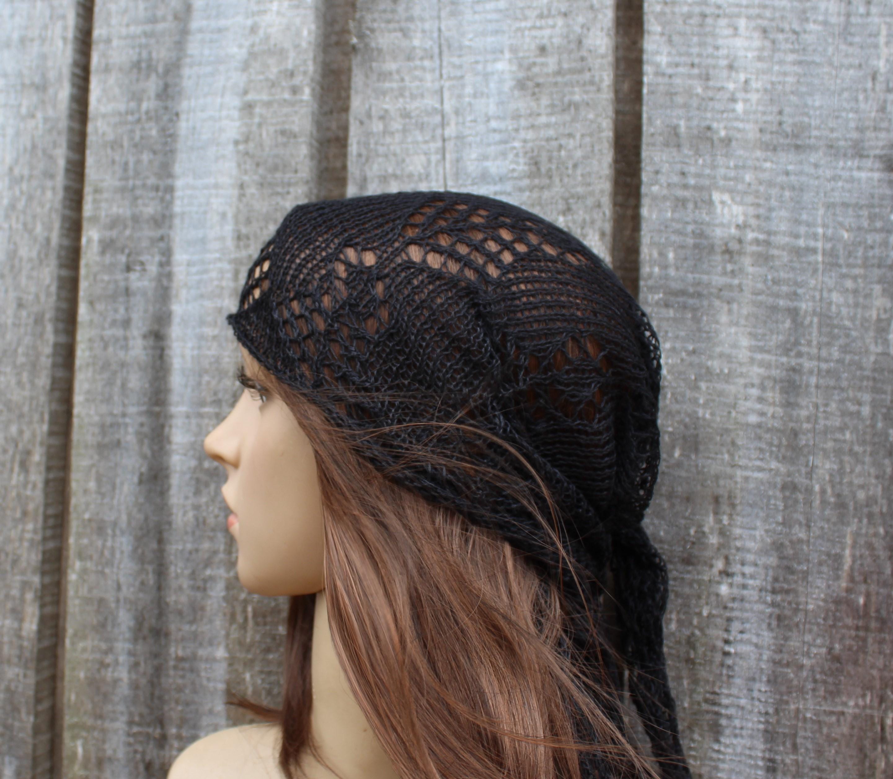 Black lace headband worn by a mannequin against a wooden panel background