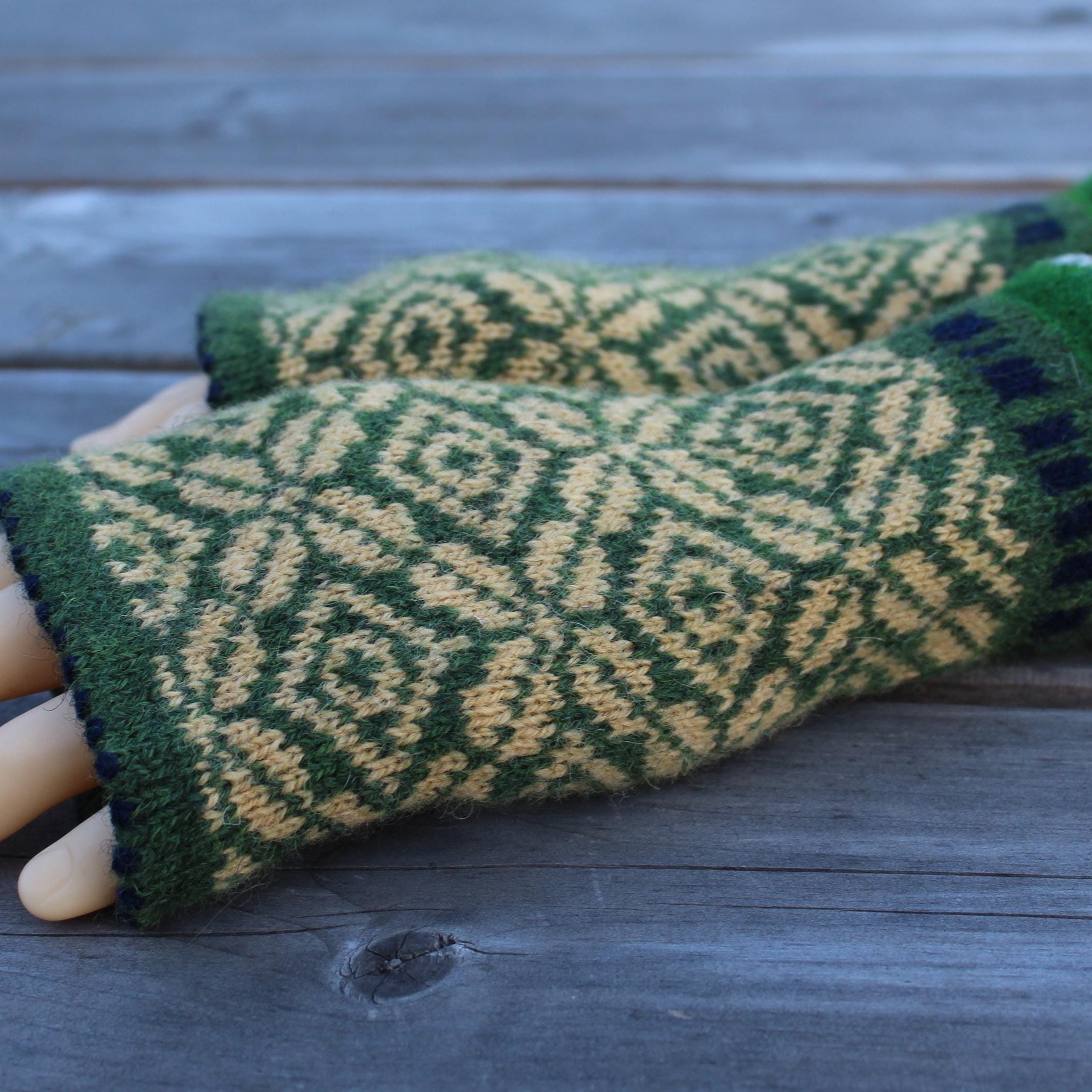 Green and yellow patterned  gloves on a wooden surface