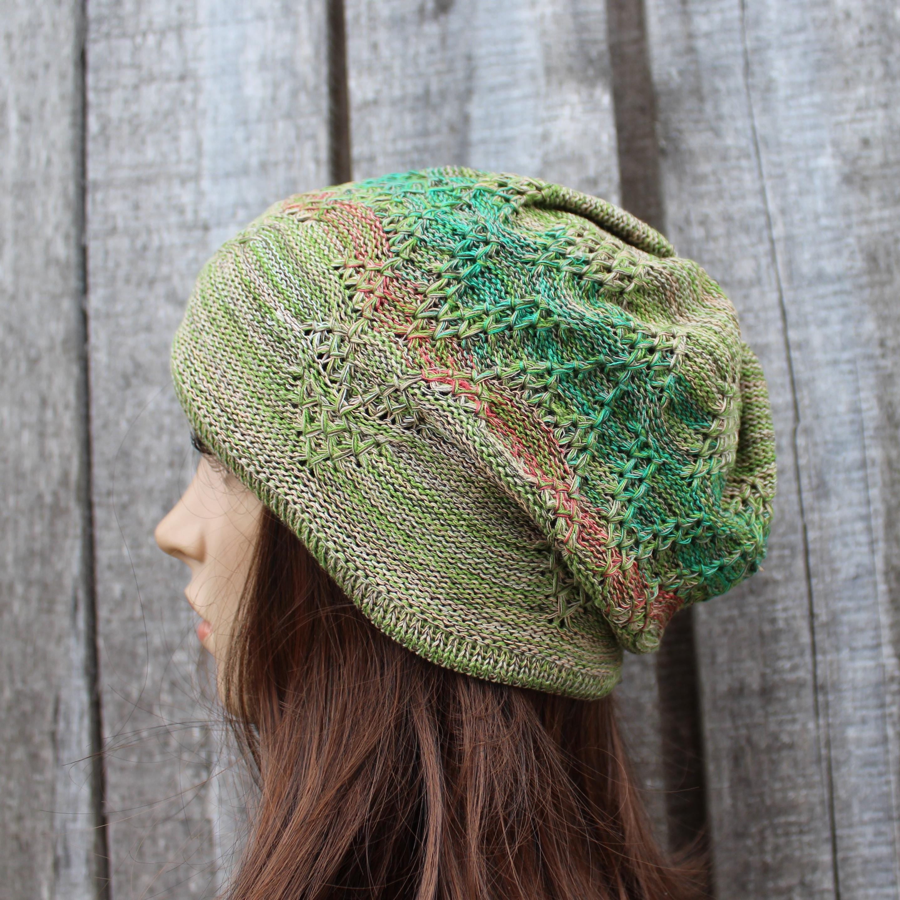 Green knitted hat worn by a person against a wooden background