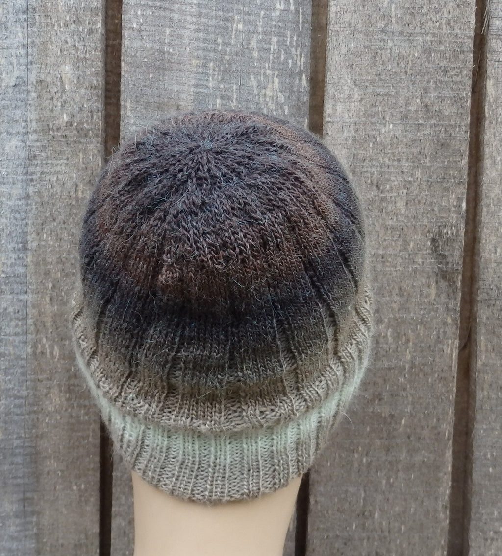 Knitted beanie with gradient color pattern on a wooden surface