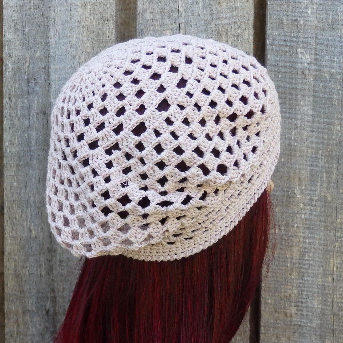 Cotton hat on a mannequin head against a wooden fence background
