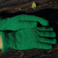 Green warm gloves on a wooden surface