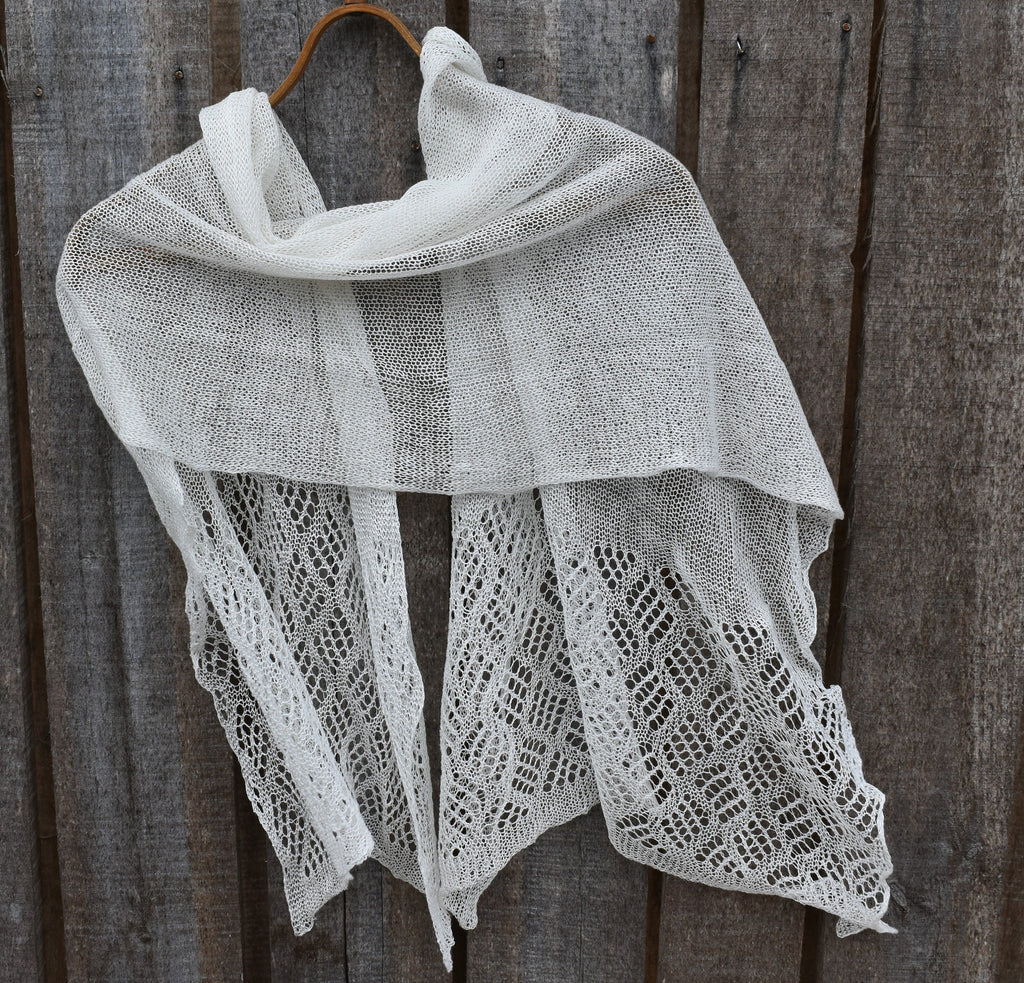 Knitted shawl draped over a wooden surface