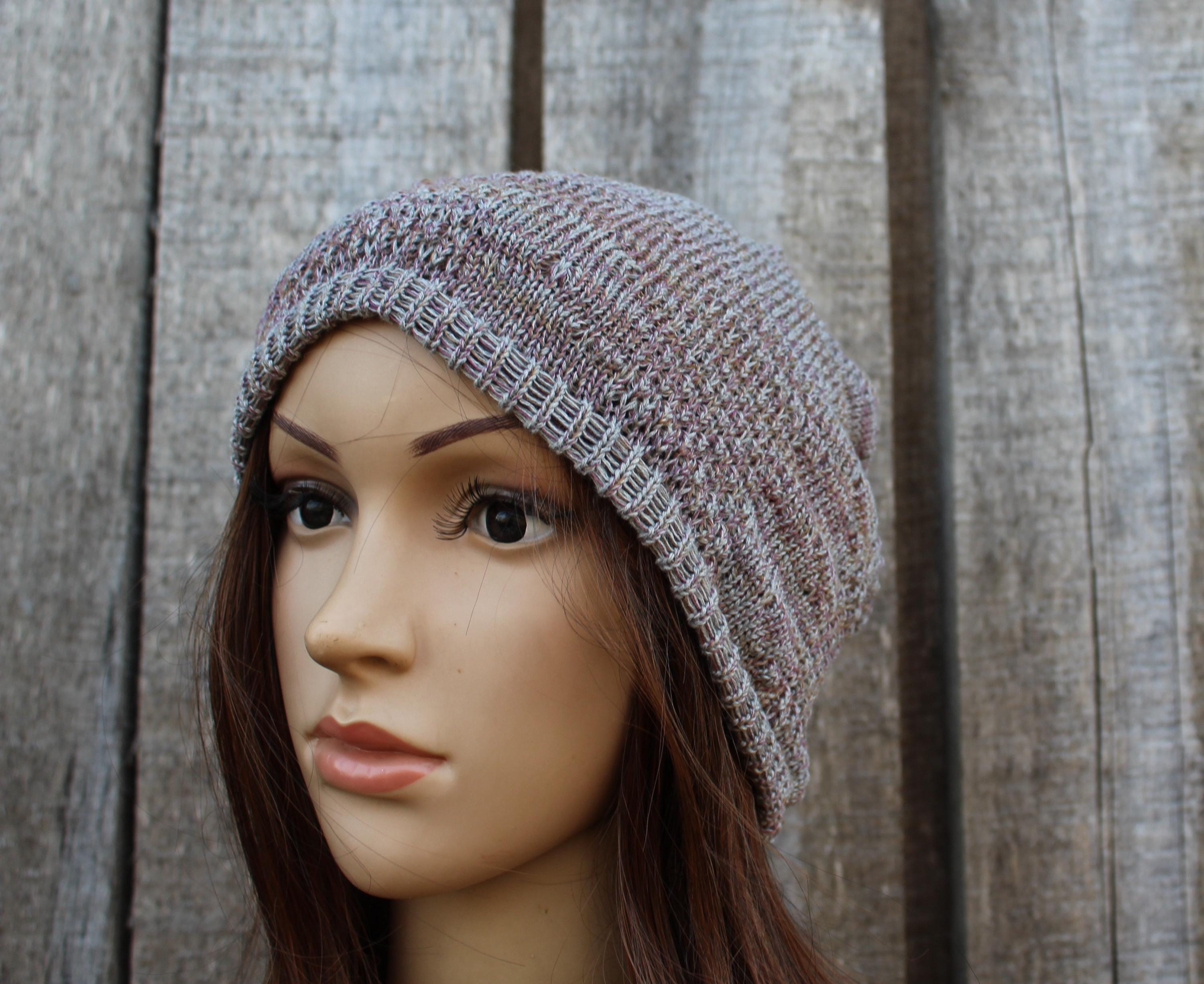 Mannequin head wearing a knitted beanie against a wooden background
