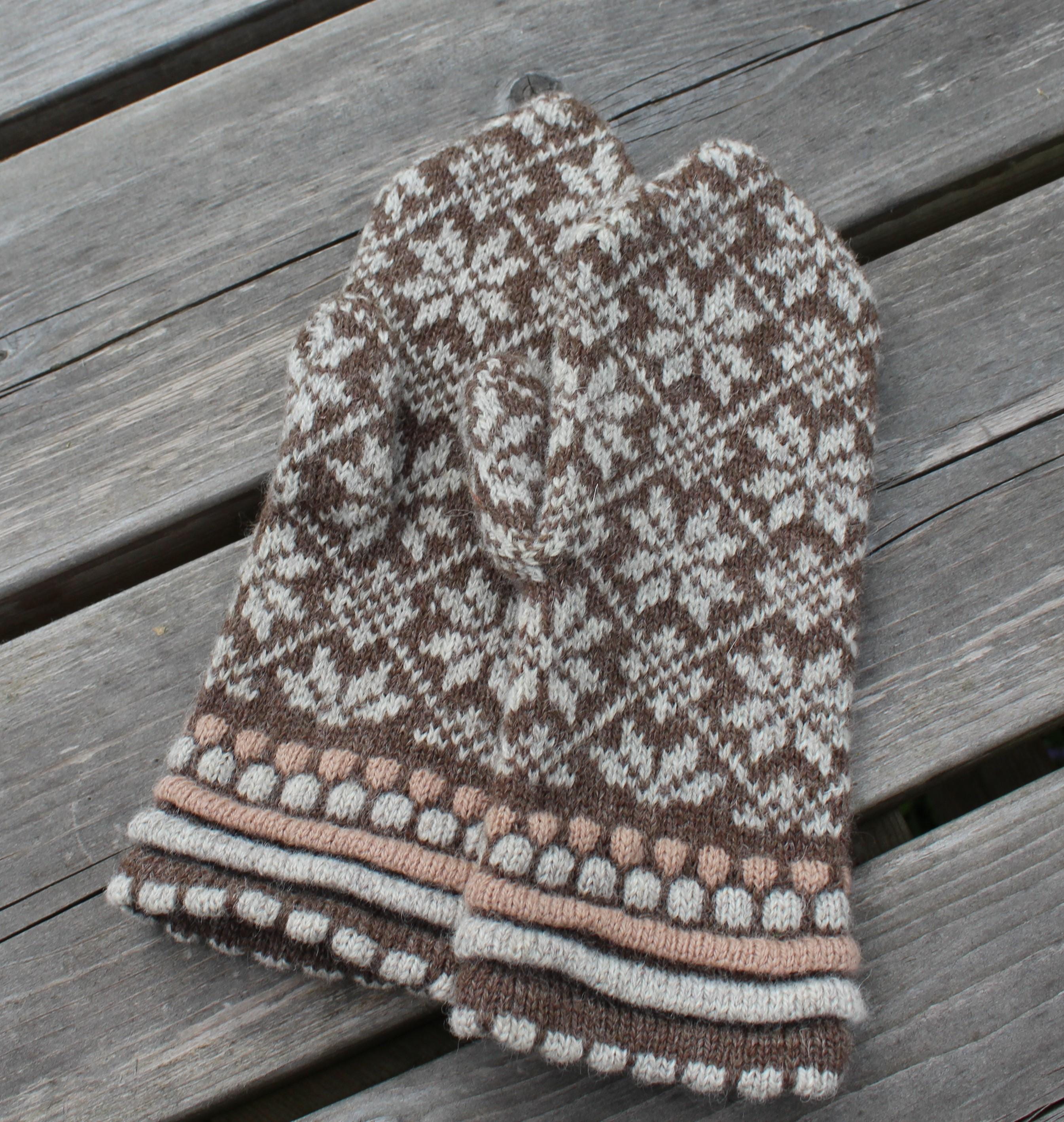 Knitted mittens with a pattern on a wooden surface